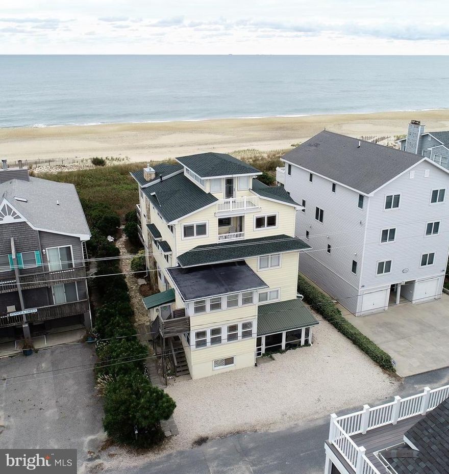 How important is the ocean and beach to you?  Do you dream of the sound of waves waking you up with the sun in your face, or seeing that full moon over the ocean with silver waves aglow?  How long have you known that SOMEDAY you will figure a way to make this dream happen?  One day, maybe sooner than later, you are just going to pick a spot.  You will turn off phones and distractions and listen to your heart.  The sea will win. Little and big footprints and paws will win too.  The day will come when your soul will speak up and not be ignored.   A  place by the sea cannot be denied and the time could be NOW.  This oceanfront home has wide open views to the beautiful white-sand Fenwick Island Delaware beach and Seashore Park.  There are many opportunities to enjoy the sea from wide decks and the interior open floor plan and living spaces. Plus it is only a short 50-foot walk to the beach path and year-round discovery in each and every season of the  year.  You can enjoy the serenity of beach life without even leaving your couch.   This Craftsman inspired coastal cottage-style beach home is one of a kind.  Originally a fishing cottage in the days when the only way to get to Fenwick Island was by boat, this oceanfront home has been substantially remodeled & expanded to maximize the approximately 180 degree view over the Delaware Seashore Park to the Delaware and Maryland Atlantic Ocean shoreline/horizon.  On a clear day from the top deck, with binoculars, you can see the Cape May/Lewes Ferry make the daily crossing back and forth. This home is truly a treasure, retaining its casual beach cottage heritage with a new spirit.  The 11 bedroom, 9-full bath home is actually two interrelated private tax units owned by a single individual. Held in a Condominium form of ownership, the house lives large, yet boasts a full indoor/outdoor open floor plan for family and friends to gather.  The size and openness easily allow for many places to get away or come together to read, play games, visit, watch dolphins play and enjoy the sunrise, coastal breezes and quiet.  There are four large oceanfront decks, two westward looking decks and a street level screened porch.  As an investment property, the possibilities for income producing rentals have been successful for the current owner for approximately 20 years and are substantial.  Take a good look at the photos and how the home flows and is laid out.  Ask for the Special Features List for more details.