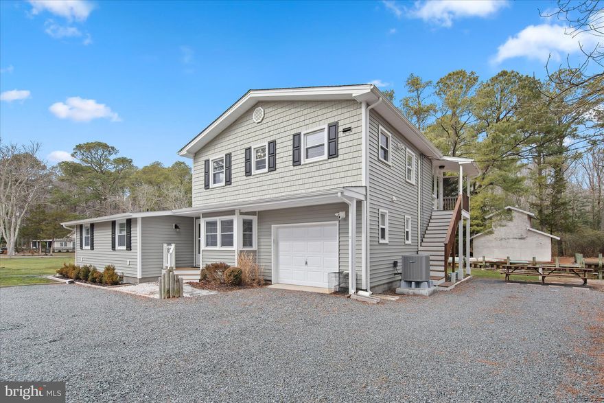 Introducing 12107 Angler Road in Ocean City, Maryland, a secluded canal-front coastal retreat where craftsmanship, character, and coastal adventure converge. Completely renovated and reimagined in 2025 by a custom home renovation professional, this exceptional duplex preserves the charm of the original residence while elevating every space with thoughtful design and top-tier finishes. The result is a waterfront property that lives beautifully as a private residence, income-producing investment, or multi-generational retreat. The main home offers three bedrooms and two full baths, including a serene primary suite with ensuite bath. The cathedral ceiling with exposed beams creates dramatic architectural presence in the main living area, while original built-ins add warmth and timeless character. Hand-scraped hardwood flooring, slate accents, quartz surfaces, designer lighting, and high-end fixtures reflect the meticulous level of execution throughout. A small but mighty Chef’s kitchen takes center stage, delivering everything the discerning cook needs. Serve meals in the dining area or take the party out to the screened porch or paver patio, and enjoy the home's tranquil waterfront surroundings. The main formal living room is complete with a beautiful energy efficient electric fireplace topped with a handsome wood mantle, the perfect space to unwind and share fishing adventures of the day. Two guest bedrooms, each uniquely appointed and a lovely hall bath are at the ready for guests. The attached apartment is equally impressive, offering two bedrooms and a full bath, its own private entrance, separate electric meter, and a proven rental history generating approximately $55,200  annually. Ideal for guests, extended family, or continued income potential. Every major system has been addressed: new roofs, new flooring throughout, fully renovated kitchens with new appliances, two HVAC systems (one brand new in 2025), and two new electrical panels. The home operates on private utilities, eliminating public water and sewer bills. Outdoors, the canal-front setting is truly the crown jewel. A bulkheaded shoreline and perpendicular dock sit on navigable waters leading through Herring Creek to Isle of Wight Bay and onward to the Atlantic Ocean. From sunset cruises to deep sea fishing excursions, even participation in the world-renowned White Marlin Open, the waterways from your backyard deliver unmatched coastal lifestyle access. Tucked away in peaceful seclusion, yet just minutes from the vibrant energy of Ocean City, this property offers the rare balance of serenity and convenience. A masterfully renovated waterfront opportunity with endless possibilities, refined, functional, and ready for its next chapter.