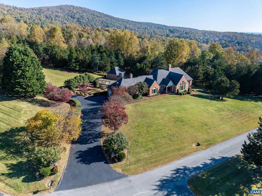 NEW PRICE-Stunning 21 acre estate atop Hansen Mountain in exclusive Shadwell Mountain. Spectacular Carter's Mountain views from newly installed east-facing windows. Elegant brick exterior with grand two-story foyer leading to soaring living room. Perfect floor plan for entertaining and easy one level living including spacious kitchen in heart of home with Kitchenaid appliances including paneled Sub-Zero refrigerator. Luxurious main-level primary suite with sitting area, dual custom walk-in closets and elegant bath. Two additional spacious bedrooms with walk-in closets plus home office/bonus room on second floor. Bonus room accesses walk-in attic with expansion potential. Rough in for additional bath in this area.  Outdoor paradise includes in-ground pool with expansive patio, screened breezeway with built-in grill, and separate pool house featuring living area, kitchenette, full bath, and bedroom. Grelen Nursery professionally landscaped, picturesque setting surround the house on 2 manicured acres, bordered by 19 acres of pristine woodland for ultimate privacy. In ground pool and pool house-great for entertaining and fun! Minutes to Pantops shopping, Martha Jefferson Hospital, I-64, UVA, and downtown Charlottesville.,Solid Surface Counter,White Cabinets,Fireplace in Den,Fireplace in Living Room