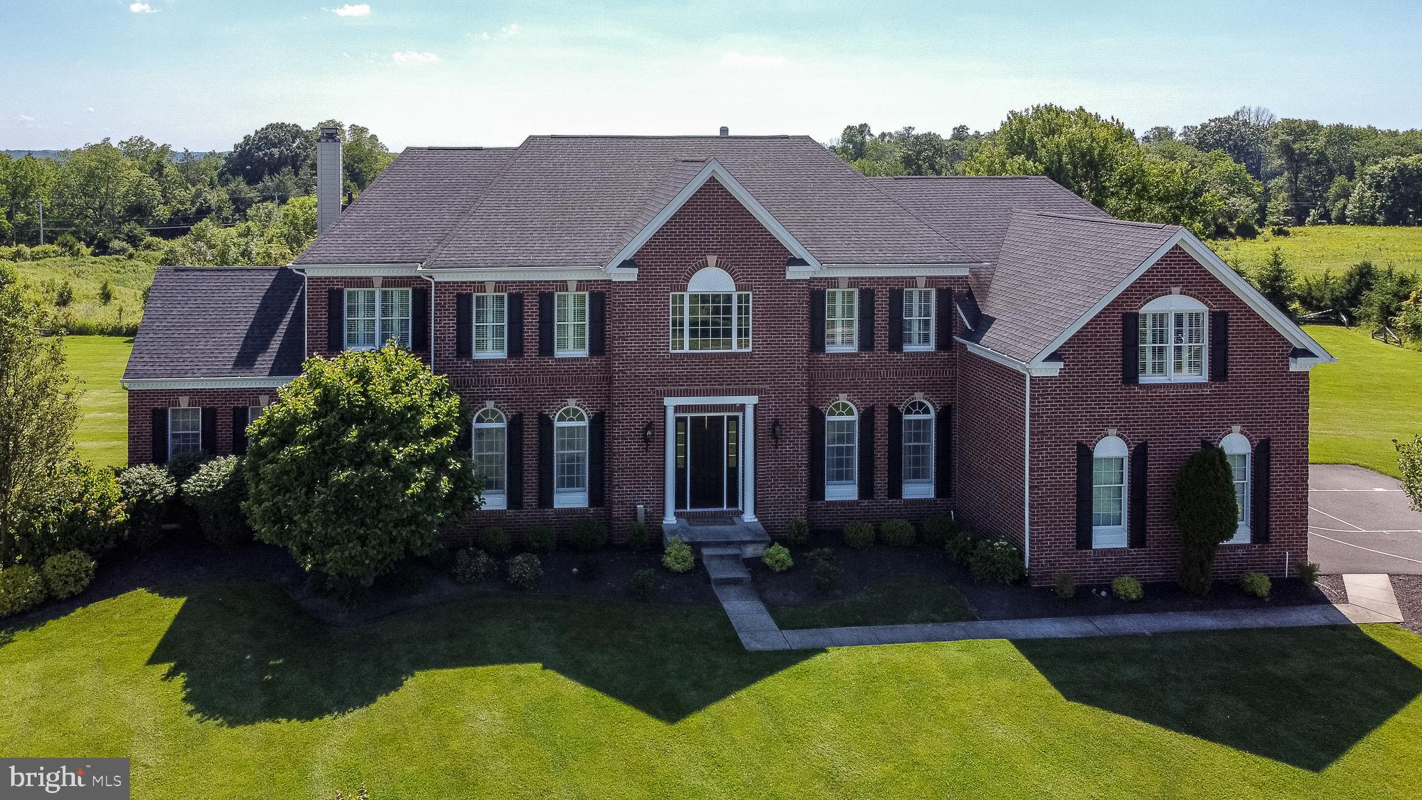 Prominently placed on the largest East side lot in the exclusive Chapman’s Corner, you will find this meticulously maintained stately brick front beauty with tasteful design selections throughout. The two story foyer with sweeping curved staircase is highlighted by the ornamental iron railing, richly stained wood floors, and contrasting crisp white millwork. The main floor showcases 10 foot high ceilings with oversized solid core doors and gleaming hardwoods create a natural flow through the formal living and dining rooms and carry through the dramatic two story eat-in open concept chef’s kitchen complete with professional series appliances, double oven, range hood with tile backsplash, and granite island. The light-filled sunroom with vaulted ceiling overlooks a scenic backyard with year round picturesque views of an outdoor sanctuary, and leads to an expansive terrace with lighted pillars and gas firepit set against a backdrop of manicured grounds and unspoiled natural beauty to dine al fresco. The sunken atrium with vaulted ceiling and loads of windows is located off the expansive family room, is wired with surround sound speaker system, and enjoys its own heating/cooling zone. When it's time to unwind, a tranquil and serene spa-like master suite allows for an indulgent escape with thoughtfully designed his and hers closets to maximize space, a spacious sitting area, currently used as a gym, and tastefully appointed ensuite bath, with private water closet, separate vanities, glass shower door and large jetted soaking tub. Four additional bedrooms reside on the upper level featuring two Jack and Jill suites. The enormous unfinished walkout lower level provides countless opportunities including rough-in plumbing for future bathroom/wet bar. Other amenities include: A variety of window treatments including plantation shutters and shades, irrigation system, outdoor timed lighting system, security system with indoor/outdoor hard wired camera system, and the list goes on. All this in an ideal location with access to Council Rock schools, including Sol Feinstone Elementary, and just minutes from the shops and restaurants in Newtown Boro, New Hope and Doylestown, and easy access to major roadways and transportation to Philadelphia, NJ and NY. 249 Jane Chapman Drive is one of the most exquisite properties to come to market in Bucks County and promises to provide years of cherished memories. Schedule your tour today and make sure to view the virtual walk thru.