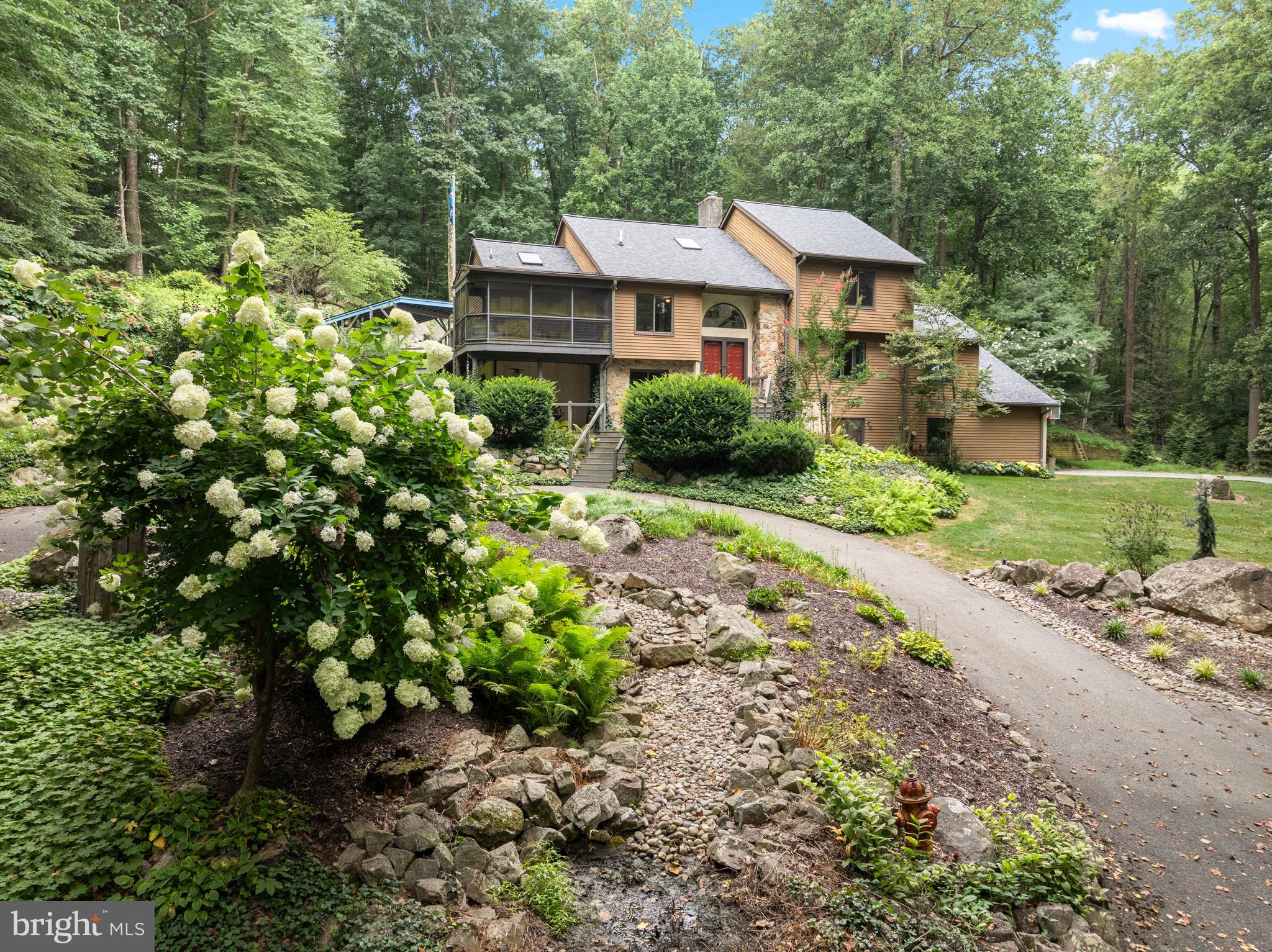 This home has been pre inspected and recent upgrades include a brand-new roof, new gutters, updated carpet, new sliding glass doors, new garage doors, and upgraded appliances—allowing you to move in and enjoy immediately. 41 Lyons Run Road is where modern sophistication and nature converge to create a private sanctuary in the heart of Glenmoore, PA. This architectural gem is a seamless blend of contemporary design and natural beauty, offering serenity, privacy, and thoughtful functionality.
As you arrive via a private, winding lane through mature woodlands, you are greeted by curated native and natural landscaping, outlining a striking natural rock formation rising behind the home—an awe-inspiring backdrop that frames both the multi-level wrap-around deck and the bright, open interiors.
Step inside to a dramatic split-level foyer, where your journey begins. Head upward to the heart of the home or downward to a thoughtfully designed lower level. Immediately to your right, you’ll find three spacious bedrooms, including a flexible space currently used as a home office, as well as a generous laundry room complete with custom storage, built-in drying racks, and folding areas—designed with daily living in mind.
Ascend to the next level and discover a private primary suite retreat, featuring an updated en-suite bathroom, abundant closet space, and tranquil views of the surrounding landscape.
Continue upward to the main living level, where soaring ceilings and walls of glass create a bright and welcoming ambiance. The open-concept living room, dining room, and kitchen flow effortlessly together, all while overlooking the peaceful wooded backdrop. Whether preparing meals in the upgraded kitchen, dining with loved ones, or gathering by the fireplace, every space invites connection with nature and each other.
Off the dining room, step out to a charming screened-in porch—perfect for morning coffee, evening cocktails, or simply soaking in the sounds of the surrounding woodland.
The lower level offers even more versatility, with a cozy retreat ideal for unwinding with your favorite book or hosting game day celebrations. Adjacent is a multi-functional room perfect for hobbies, homework, or additional entertaining space, complete with a gas stove for added warmth and ambiance. Outside, this home is made for enjoying every season. A flat, sunlit side yard invites gatherings of all sizes, while a fire pit area is ready for evenings under the stars.
Situated on 2.8 acres, this home provides unmatched tranquility while remaining close to the vibrant communities of Chester Springs, Exton, West Chester, King of Prussia, and the Main Line, as well as major highways including RT 100, 202, the PA Turnpike, and the Blue Route. Moments from local favorites like Ludwig’s Corner, Limoncello, Brickside Grill, and much more.
41 Lyons Run Road offers the perfect balance of refined living and natural beauty—an invitation to experience life at its most peaceful and inspiring. Note: a few photos of been enhanced using AI to show you what the rooms would like like if you wanted to paint them.