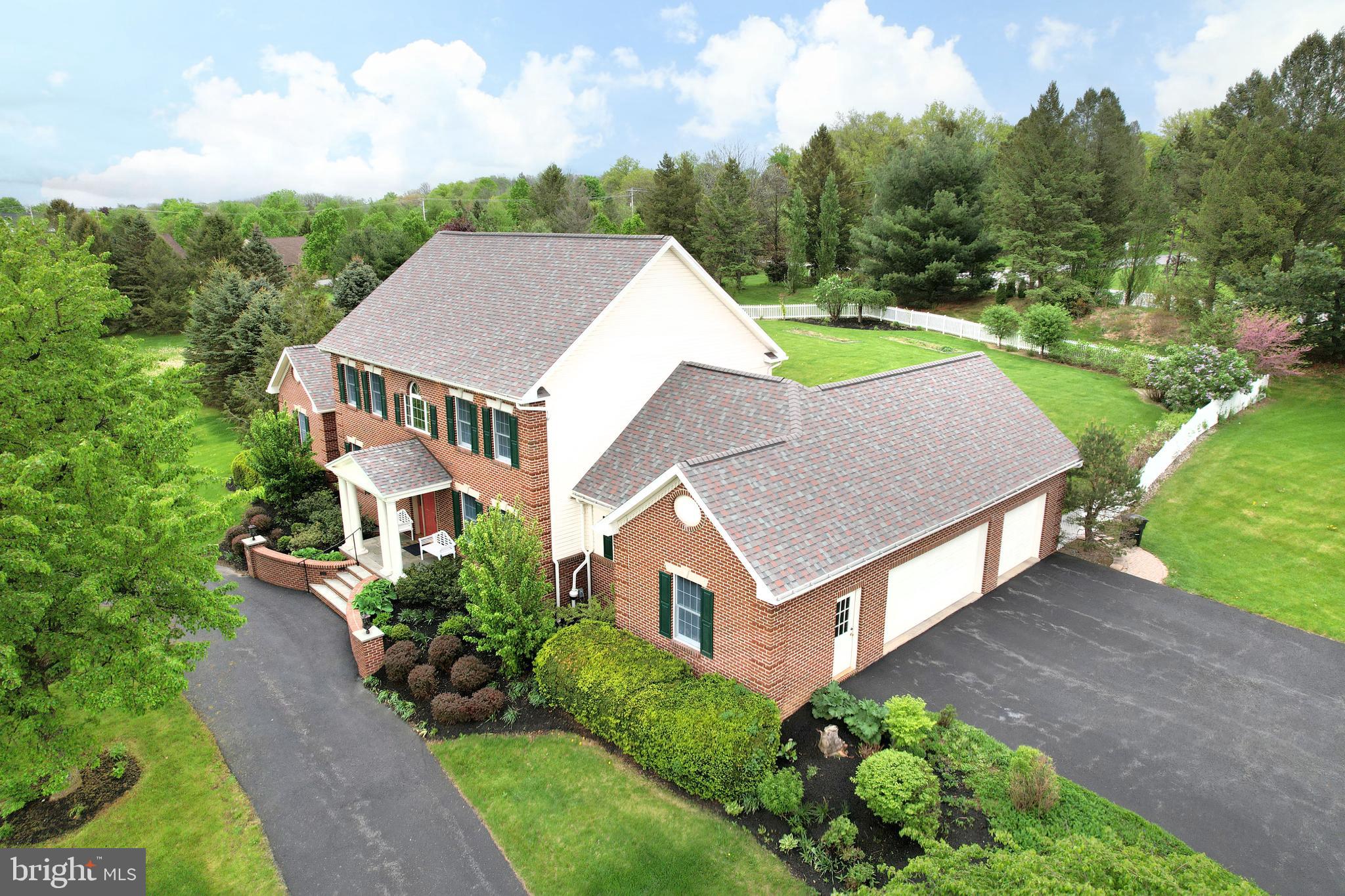 Beautiful brick two story built by Paul Stumpf on 2 acres in wonderful Aspen Heights! With an impressive circular driveway and a welcoming covered front porch with lit slate steps, you'll feel at home pulling up. Enter into a two story foyer with a turned staircase and expansive hardwood flooring on the main floor. The large front office provides a great view while the sizable front dining room, currently used as a music room, will accommodate large dinner parties. Cooking is a delight in the enormous, remodeled chef's kitchen complete with plentiful quality cabinetry, granite countertops, a large island with cabinets on both sides, two pantry cabinets with pullouts, newer stainless steel appliances including a double oven and gas cooktop, and ample lighting. The spacious great room boasts a vaulted ceiling, a gas fireplace, and access to the partially covered rear patio, while the generously sized main floor primary suite boasts a sitting area with patio and hot tub access, a spa like bath with a walk-in shower and jetted tub, and a large walk-in closet. A main floor laundry/mudroom with storage cabinets and a utility sink and a half bath complete the main floor. Upstairs you'll find four bedrooms with two Jack-and-Jill style baths giving each bedroom their own sink area. Have fun in the sprawling finished lower level featuring built-ins in the family room, a hobby space, an office/guest room, a half bath, and a large storage and utility room. Relax on the expansive rear paver patio taking in the private and nicely landscaped & fenced yard or get loose in the hot tub. With a three car garage and extra driveway space you'll have plenty of room for cars and toys. Situated on a very private lot in an upscale neighborhood that's close to the shops, restaurants and parks of Boalsburg, Mountain View Country Club, Rothrock State Forest and Tussey Mountain Ski and Fun area, yet not far from downtown State College and Penn State via the highway, you'll love the location. Luxury living awaits you!