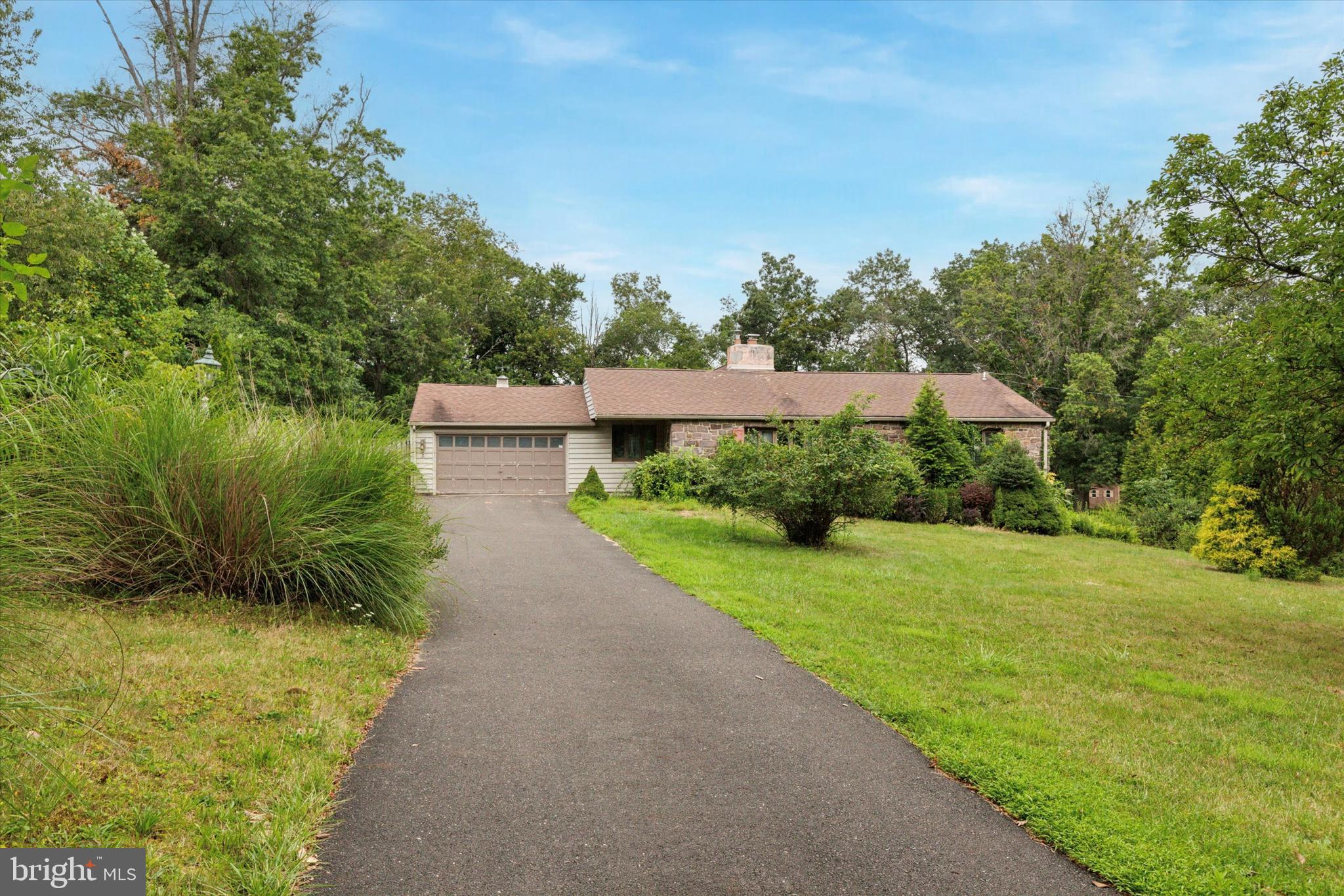Opportunity awaits in Buckingham’s Sunnyside Acres! This large ranch home is situated on just over an acre and is an excellent opportunity to renovate to your taste and add loads of value in the process. Entering the home, you’ll step into a large sun lit living room and dining room area with a stone wood burning fireplace. The kitchen has access into the 2-car front entry garage and also connects to a huge family room with vaulted ceilings, another fireplace, and access out to the rear yard and patio area. There are three bedrooms – one of which is currently connected to the kitchen and was formerly used as a home office/study space but can easily be converted back to the 3rd bedroom. There is a hall bathroom and two additional bedrooms, including the main bedroom which has its own bathroom ensuite. The full basement offers plenty of storage space, and potential to finish into additional living space. In addition to the garage, there is a large driveway offers plenty of parking. This home will need renovations and is being sold in “as is” condition. Sunnyside Drive is tucked away and has a back road Bucks County vibe while being just around the corner from all the conveniences of the area – None Such Farm market is just around the corner, and there is quick access out to York Road, Route 202, Doylestown, New Hope and so much more. Come visit 4270 Sunnyside Drive and find your way home!