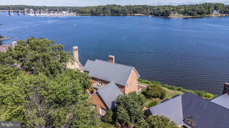 Enjoy resort-style living in this lovely brick home sited on the edge of the South River and only a few steps to a nature path and private sandy beach.  Other notable amenities in the desirable South River Landing community include a deep water marina, swimming pool and clubhouse off the protected waters of Almshouse Creek, tennis courts, playground and 24/7 gated and staffed security. This distinctive 4,650 sq. ft  home embodies natural light and panoramic water views from nearly every room, emphasized by abundant picture windows and tall ceilings. The lofty 2-story Great Room showcases a floor-to-ceiling, 2-sided fireplace which frames the South River.  Huge views are also captured from the Dining Room and the Morning Room off the Kitchen. A convenient shady covered deck is accessible from all social spaces and opens to a renovated and extended waterfront deck with cable railing. The main level Primary Suite features a sun-drenched super bath with cathedral ceiling, walk-in closet and private waterside deck. Handsome hardwood floors extend throughout most of the main level, including the Primary Suite, then up the wide staircase and upper level landing.  This hardwood bridge has a unique vantage point overlooking the front of the property and also the Great Room, while connecting the upper level bedrooms.  All 3 spacious, upper-level bedrooms enjoy a birds eye view of the South River. On the lower level, a vast Recreation Room with 9 ft ceilings can offer a variety of uses and highlights a 2-sided masonry fireplace, wet bar and a full-length wall of waterside windows and doors.  A full bath is tucked away for privacy and convenience while the 5th bedroom offers its own en suite bath and water views. The lower level opens to a covered flagstone waterfront patio to the grassy lawn. Significant storage space over the 2-car Garage is safely and easily accessible from a fixed staircase. (50-yr CertainTeed cedar-simulated composite roof and gutters in 2012) The community association fee covers your lawn mowing, mulching, trimming and snow removal while also maintaining the marina, pool, tennis, playground, nature path and 24/7/365 staffed gated security.  Boat slips for rent or purchase based on availability.