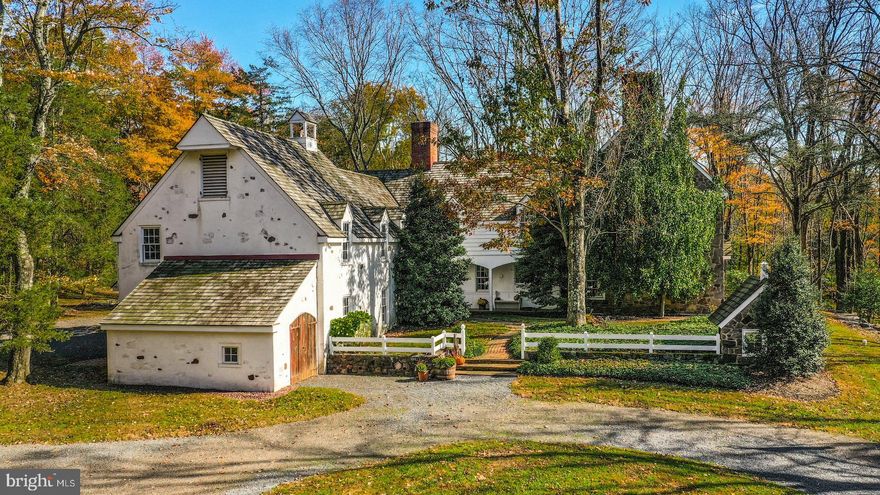 This elegant estate home is reminiscent of an English country manor, but was custom built in the 1970s by a prominent local family. The dramatic 4 acre wooded parcel is a stunning setting for the home, which includes an in-ground pool and unique barn space. With more than 5,700 square feet including six bedrooms, four and a half baths and an incredible eight fireplaces, Lower Mountain Manor is ideal for family, friends, and entertaining. Large rooms and high ceilings are defining features, along with pegged oak floors, abundant windows, and Delft tile. The spacious foyer opens to a large dining room, sunken living room, and office or library space with built-in shelves. Lots of storage and prep space is found in the eat-in kitchen, with Delft tile countertops and an island, as well as doors to two covered porches. Five main bedrooms upstairs include a luxurious primary suite with multiple closets, as well as another large suite and three hall bedrooms. A guest suite is accessible from this floor and has its own exterior entrance as well, with a private living room and bath. A 2-car attached garage has separate equipment space for hobbies or other vehicles. Across the driveway stands a large barn with massive doors that open to a lofted storage area, as well a 2-car garage and equipment bay.