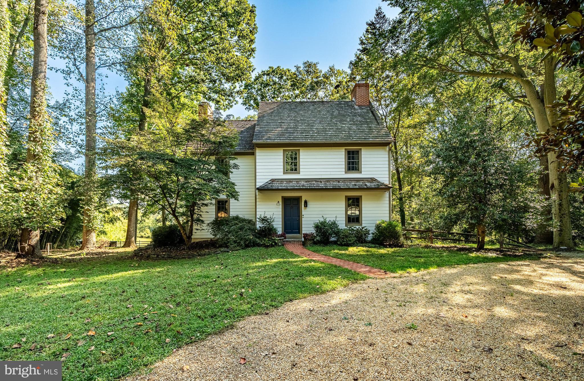 Down an allée driveway lined with mature cherry trees, this 1700's reproduction home designed and built by renowned custom builder, Curt Bagnall, has all the charm of a classic farmhouse but fully upgraded with all modern amenities. Overlooking acres of rolling fields and abutting conserved properties, the house is perfectly sited to capture one of the most spectacular views in Chester County while providing complete privacy amongst mature specimen trees. Featuring custom woodworking and period details throughout, the home has unparalleled character. With raised paneling, wide-width hardwood flooring, antique hardware, numerous fireplaces, custom gourmet kitchen, amazing primary bedroom suite, great room and finished lower-level family room, this home has it all. The large great room with floor to ceiling windows opens out to the expansive deck that takes in the sweeping view and provides the perfect place for outdoor entertaining. The primary bedroom suite features a sitting room, fireplace, bathroom, two large walk-in closets, large windows, raised ceiling, and a private balcony that is the perfect quiet spot to take in the magnificent view. The finished lower level features a family room with brick flooring, a large fireplace, a large laundry/utility room and a workshop. The lower-level family room and workshop both have windows and their own on grade access. For the equestrian, gentleman farmer there is a 4-stall barn with wash stall, tack room and loft above, a riding ring with footing in the center of the circular driveway, and several fenced paddocks. The barn is also a great space for an artist or hobbyist - the loft is used by the present owners as an art studio. The highlight of the property is the priceless protected view across the Pocopson Creek valley. This property is a true retreat. Located in the award-winning Unionville-Chadds Ford School District and just a stone's throw from West Chester, Chadds Ford and Kennett Square, with easy access to all amenities and the Philadelphia Airport, this is a one of a kind property offering the best of Chester County living.