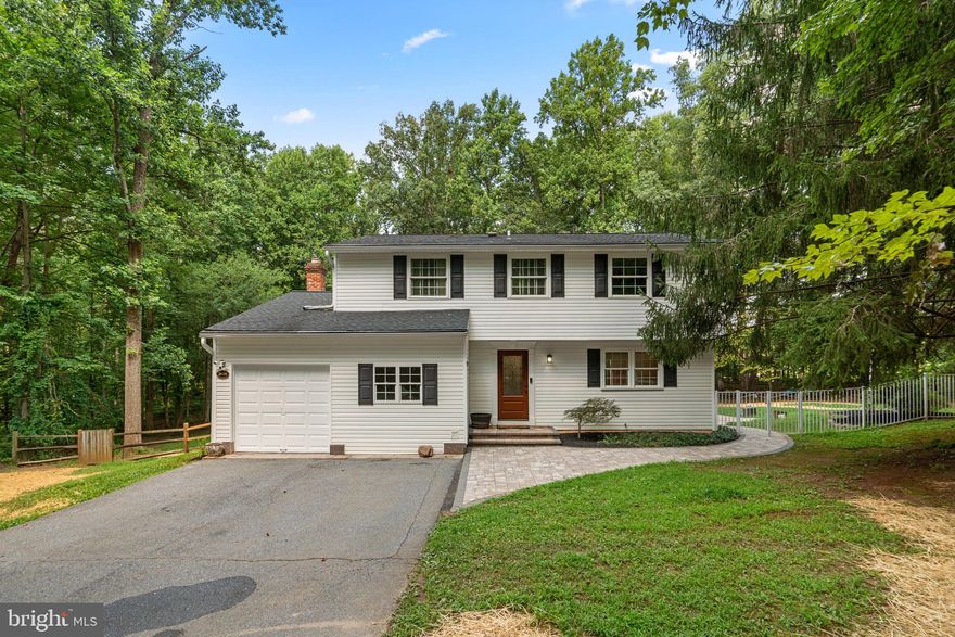 Gorgeous Colonial residence offering 2,330 square feet, 4 bedrooms, 2 full bathrooms, 2 half bathrooms, and a 1-car garage, in sought-after Marriottsville. A charming front patio welcomes you into the home, where rich hardwood floors flow through the foyer and into the thoughtfully designed main level. To the left, a private study or home office features built-in bookcases. To the right, the layout opens into a spacious living room and a formal dining room with elegant chair railing and sliding glass doors that lead out to the pool area. The inviting family room is filled with natural light from skylights and features a cozy wood-burning fireplace with whitewashed exposed brick, which opens into a sunroom with radiant heated floors and panoramic windows overlooking the backyard, creating a seamless connection to the outdoors. The eat-in kitchen is warm and welcoming, featuring granite countertops, rich cabinetry, a backsplash, stainless steel appliances, a pantry, and a breakfast bar—perfect for casual meals. The powder room and a convenient laundry room with garage access complete the main level. Upstairs, you'll find four comfortably sized carpeted bedrooms and two full bathrooms, both updated in 2023. The primary suite includes a separate vanity area with a sink, a large walk-in closet, and a private en suite bathroom with a second sink and a beautifully tiled shower. The fully finished lower level provides additional living space on both sides of the staircase and includes built-in cabinetry, a cozy corner seat, and built-in shelving. Outdoor living is truly exceptional, featuring an expansive deck and patio that surround an in-ground heated pool (heater added in 2023), complete with a slide and diving board. A convenient poolside half bath with private exterior access means no one has to enter the home wet, perfect for quick changes or bathroom breaks during pool days. The large, fenced backyard offers a private retreat, bordered by mature trees for natural seclusion. A charming stepping stone path winds through the yard, leading to a second patio with a built-in fire pit and a spacious storage shed—perfect for year-round entertaining and relaxation.