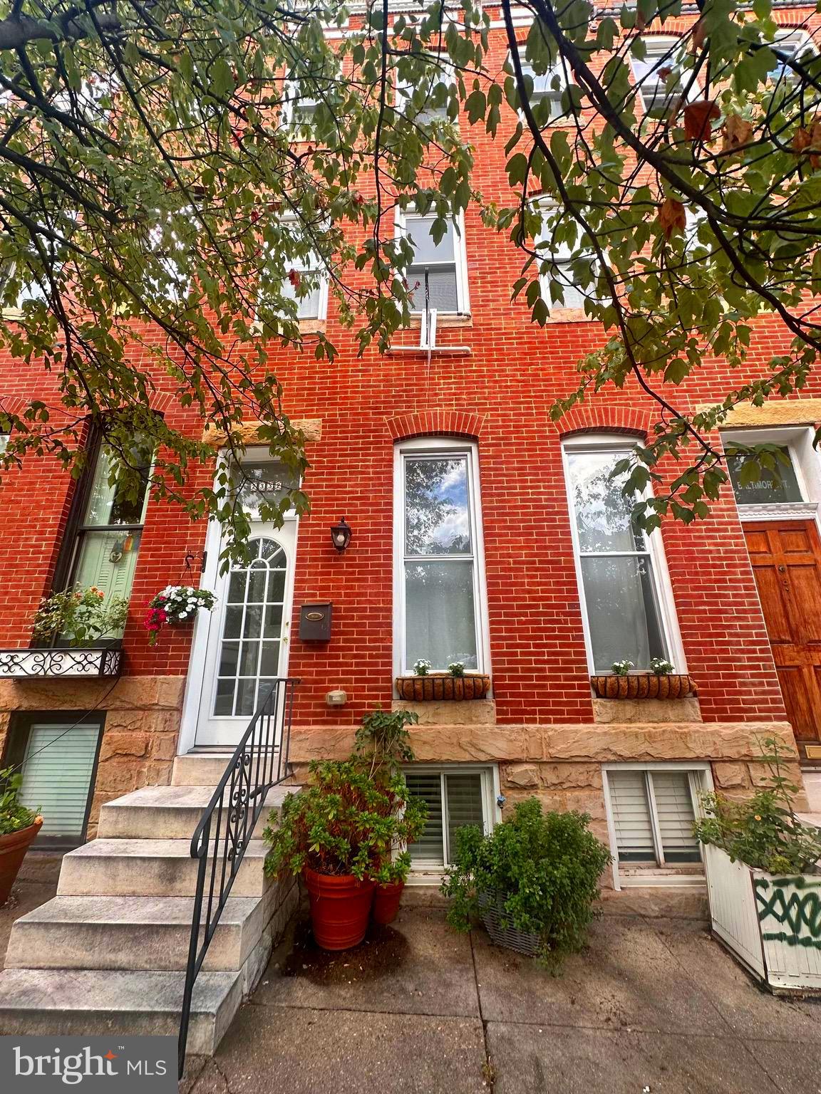 Overlooking the park and rich with original character, this beautifully preserved three-story home offers the perfect blend of 1920s craftsmanship and thoughtful modern updates.
Step through a formal foyer into the elegant living room, where high ceilings, gleaming inlaid parquet floors, large sun-filled windows, and a decorative fireplace mantle create a warm and inviting atmosphere. A separate formal dining room provides the perfect setting for hosting gatherings, while the spacious eat-in kitchen features double-level white shaker cabinets, a gorgeous backsplash, and exotic granite countertops. A conveniently located half bathroom is discreetly tucked behind the kitchen. From here, step outside to a beautifully landscaped yard complete with a synthetic decking system, shaded by a mature tree—an ideal spot for outdoor dining and entertaining.
Take the graceful winding staircase to the second floor, where you’ll find two generously sized bedrooms, a flexible walk-through space perfect for a reading nook or home office, and a fully renovated bathroom adorned with Italian-inspired tilework.
The third floor serves as a private suite, featuring a spacious primary bedroom and a beautifully renovated Mediterranean-style bathroom complete with a walk-in shower —offering a tranquil, spa-like retreat.
The finished lower level adds even more versatility, offering additional flex space ideal for a guest suite, rec room, or home gym—complete with its own full bathroom.
This home also offers great mechanical updates for both comfort and efficiency, including a modern radiator system—widely regarded as a healthier heat source—and a two-zoned HVAC system for economical, energy-efficient climate control.
This one-of-a-kind home seamlessly blends preserved historic beauty with stylish, modern comfort—all in a prime parkfront location.