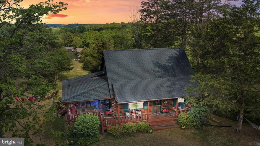 Located on the public side of Lake Anna and featuring 150 feet of riprap shoreline, this storybook Cape Cod log home is tucked away in the gated Kelly’s Landing community. Set within a peaceful no-wake cove, the property combines calm waters with a sandy bottom —ideal for swimming, floating, and unwinding. Designed for effortless lake living, it features a covered boathouse with electric lift, jet ski lift, composite decking, sun deck, and even a private boat ramp. Paver steps lead you gently into the water, while a lakeside fire pit and blooming rose bushes frame unforgettable evenings by the shore. Golf cart conveys! Inside, nearly 2,000 finished square feet unfold across three levels with warm, inviting character throughout. Vaulted wood ceilings anchor the open-concept main level, where the kitchen, dining, and family room flow seamlessly toward a lakeside bay window. A main-level bedroom with private bath, along with a half bath for guests, offers flexibility, while upstairs features hardwood flooring, a loft-style bedroom, and an additional bedroom with its own full bath. The walkout lower level expands your living space with a second family room, two bedrooms, laundry, and rough-in plumbing for a future bath. Much of the furniture and select furnishings convey, creating a true turnkey experience. Set on 1.82 private acres, the home is wrapped in outdoor living spaces, including a spacious covered side porch that flows to the rear deck—ideal for dining, relaxing, and entertaining. With high-speed FiberLync internet, a storage shed, recent HVAC (2024), roof replaced 12 years ago, and a covered porch addition (2014), the home balances rustic charm with so much comfort. Located less than 2 hours from Washington, D.C., this home is perfect for even a quick weekend trip. Enjoy close proximity to local dining and favorites like Tim’s at Lake Anna, Moo-Thru for ice cream and mini golf, The Cove restaurant, and nearby marinas. Short-term rentals are permitted, offering excellent investment potential or the opportunity to enjoy a private waterfront escape that feels worlds away, yet remains within reach.