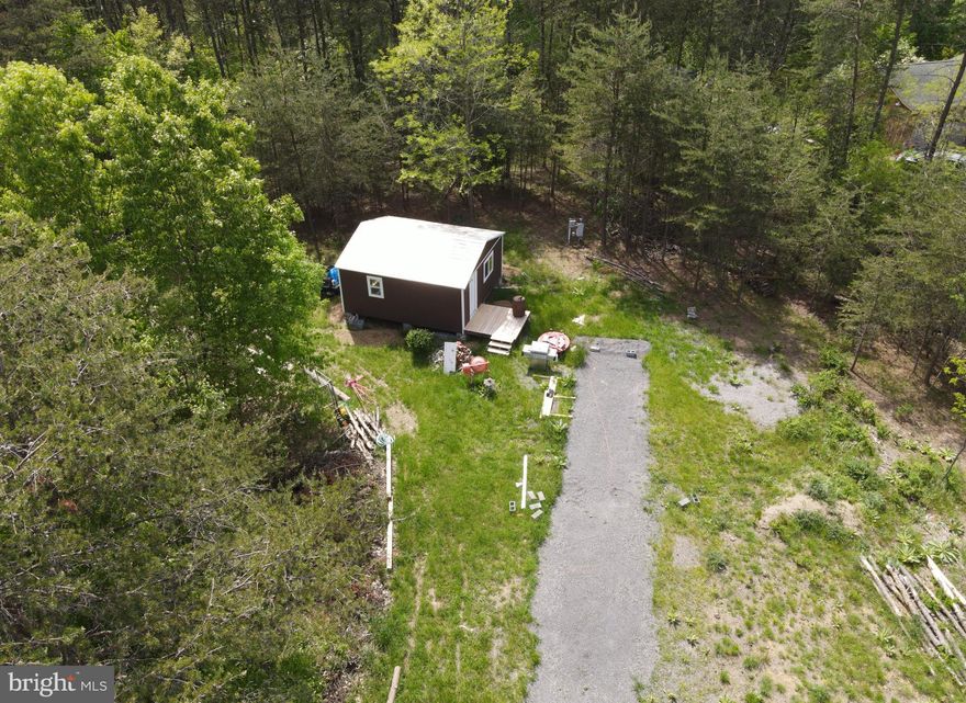 Nestled in the serene woodlands of Berkeley Springs, WV, Lot 24 Clear Spring Trail offers a rare combination of seclusion and convenience. This 3.07-acre property comes fully equipped with a septic system designed for a 4-bedroom home, a well with frost-free capabilities, and electricity on-site, ensuring a smooth start to your building plans.
The lot boasts a large shed, perfect for storage or a workshop, adding practical value to the land. The surrounding woods provide a private and peaceful setting, ideal for those seeking to escape the hustle and bustle of city life.
Despite its privacy, the property is conveniently located near Cacapon State Park, known for its beautiful hiking trails and recreational facilities. The historic town of Berkeley Springs is just a short drive away, offering charming shops, art-filled galleries, and cozy eateries. For a more urban experience, Winchester is within easy reach, providing additional amenities and attractions.
This property is a haven for nature lovers and a blank canvas for your dream home. With its ready-to-use amenities and prime location, Lot 24 Clear Spring Trail is where your vision for a tranquil country living can become a reality.
For more information or to schedule a visit, please contact us. Embrace the opportunity to build your dream amidst the beauty of West Virginia.