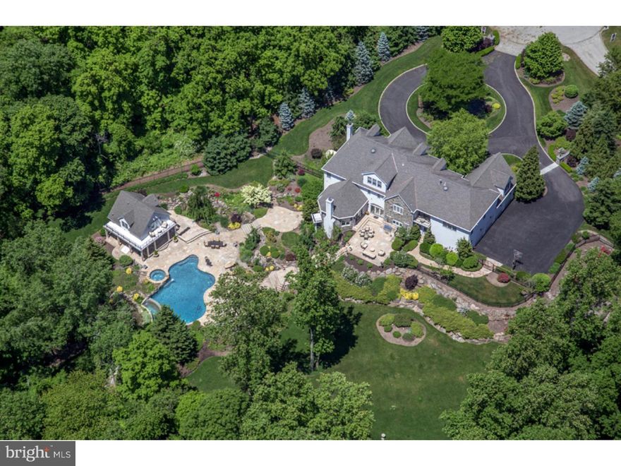 Great new price; this is an incredible opportunity on 10 private acres in Whitemarsh. Two stone entrance piers greet you as you enter this elegant, completely private custom-built home at the end of a cul-de-sac. Your arrival is welcomed by a circular drive lined in Belgian blocks, with a center island of landscaping, 2 waterfalls and a koi pond. The picturesque grounds are graced by a free-form infinity-edge swimming pool with Whirlpool, surrounded by cascading waterfalls, Tennessee flagstone patios and terraces, an outdoor fireplace, outdoor kitchen and changing area with bath at the 1-bedroom guest house. This 3-story + lower level home lacks for nothing, from the high-end custom finishes to the state-of-the-art systems, mud room, dog wash, home gym, laundry room and temperature-controlled wine cellar that make everyday life complete. Vaulted, coffered and wood beamed ceilings, wainscoting and woodwork, crown and chair rail moldings, extensive custom built-ins, hardwood floors, walls of windows and charming fireplaces add character, while modern conveniences like central stereo/surround sound, a biometric security system with cameras and back-up generator ensure your ultimate comfort. A 2-story marble reception hall brings you into expansive living and entertaining space with a living room, dining room, butler's pantry with cabinetry, granite counters, stainless steel sink and Bosch dishwasher, chef's dream kitchen with radiant heated tiled floors, sunny breakfast room accessing the stone terrace with built-in Viking grill, and huge family room with a custom wet bar, built-in work station, French doors to a Juliet balcony overlooking the pool plus access to the upper deck. One of 5 bedrooms, the spacious master suite boasts a sitting room, 3 fitted walk-in closets, a private balcony, and spa-like bath with barreled ceiling, radiant heated floors, Whirlpool tub and frameless glass shower. The lower level is a perfect haven with a wine cellar and tasting room, mirrored gym with theater surround sound, and large day-lit rec room leading to the lower terrace and pool area.