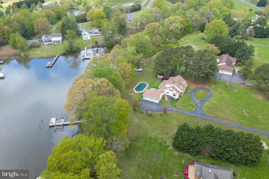 Tucked away on 2.21 acres in the well-established community of Governor Grason Manor, privacy and gorgeous sunset views define this wonderful five bedroom, four + bath home that faces the renowned Wye River.  There is a large circular driveway and an oversized three car garage for added convenience. The beautiful waterside in-ground heated pool, private dock and multiple boat slips add a great deal of pleasure to this coastal style property. The main floor features a primary bedroom and ensuite bath, two more bedrooms, a full bath, hardwood floors, a gourmet kitchen with stainless steel appliances and a large center island, a mudroom that includes a full-size washer and dryer, storage closet and access to the garage. The family room with its charming wood burning fireplace, offers a comfy respite as well as the expansive four-season sunroom that’s great for entertaining. The guest apartment on the second floor includes a large comfortable living room with breathtaking water views, a primary bedroom with ensuite full bath, a guest bedroom, an office, a second full bath, full kitchen and laundry. This spectacular waterfront retreat with its thoughtfully designed flowing floor plan offers lots of light in a tranquil private setting. Enjoy boating to nearby restaurants as well as crabbing and fishing with friends, and the benefits of being surrounded by nature.