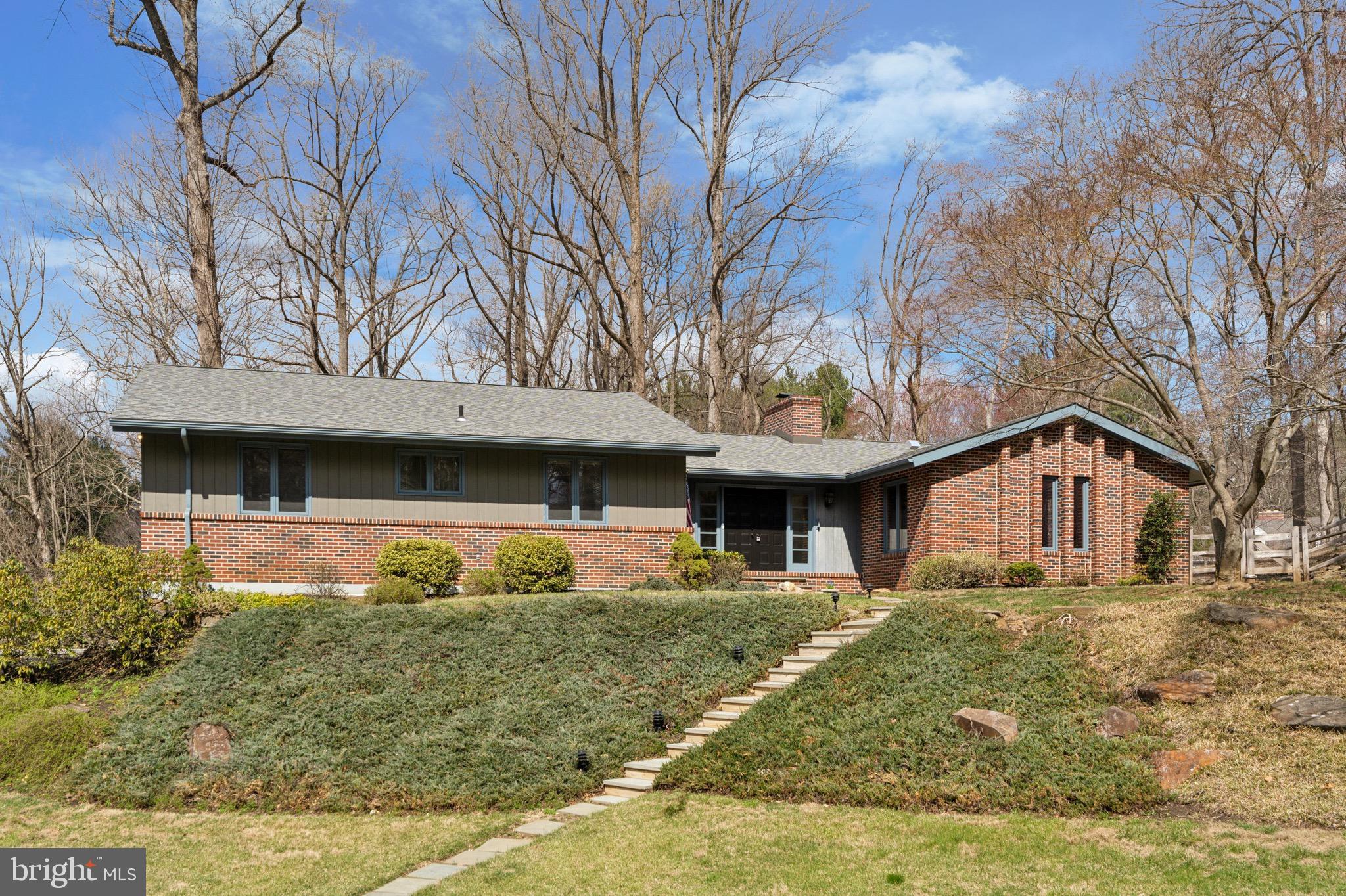 Welcome to 13 Hunters Lane. This beautifully designed 4-bedroom, 2.5-bath mid-century home is quietly situated on a cul de sac street, and offers the perfect blend of updated indoor spaces and serene outdoor beauty to enjoy year-round. This charming retreat is located in the picturesque town of Chadds Ford, Pennsylvania.
Step inside to discover original parquet floors, and then a spacious living room, where large windows flood the space with natural light. Original beams, a floor to ceiling brick fireplace and thoughtful design details create an inviting space to gather. The thoughtfully re-designed kitchen, complete with new countertops, appliances, backsplash, lighting, an enlarged central island and more, is perfect for both everyday meals and entertaining. Just off the kitchen, the dining area provides a cozy gathering space with a unique built-in and direct access to the screened-in porch, offering a seamless connection to the outdoors.
The screened-in porch serves as an ideal spot to enjoy the beauty of nature while being protected from the elements. Whether sipping morning coffee, unwinding with a book, or hosting guests, this space highlights the serene sounds and views of nature that surround this home.
The primary suite offers a private retreat, featuring a generously sized bedroom flooded with natural light and beautiful views, a full en-suite bath, and a walk-in closet. There are two additional main-level bedrooms with generous closet space, and a full hall bath with a large stall shower. Original mid-century details, exposed beams and original trim highlight the quality and integrity of the home.
The daylight lower level is a standout feature, boasting a spacious family room with a wood stove. Large windows bring in natural light and showcase the beauty of the backyard. Conveniently located next to the family room, is an updated half bath and laundry room, as well as access to the back yard. There is also a versatile fourth bedroom on the lower level, perfect for a multitude of uses such as an at home office, guest suite, au pair quarters, or creative studio.
Outside, the lush backyard offers a tranquil escape, with mature trees and open space to enjoy nature. The outdoor areas feel secluded yet expansive, and provide endless opportunities for relaxation and recreation. This home features many unique features and upgrades such as a new roof in 2020, newer HVAC systems, upgraded water treatment systems, updated baths, kitchen, flooring and much more! And for your convenience, should the power go out, an automatic built-in generator will keep you warm in the winter and cool in the summer. There is even an electric dumbwaiter adjacent to the oversized two car garage that will effortlessly hoist up your groceries and goods to the main level with the push of a button. There have been many upgrades to this lovely home, and you will be surprised at how much storage is available in many thoughtful places throughout.
Tucked away on a cul de sac, yet incredibly accessible to major routes, and amenities, 13 Hunters Lane offers the perfect balance of comfort, convenience, and natural beauty. Homes like this don’t often become available— make your appointment today to secure your opportunity to be the next owner of this beautiful property.