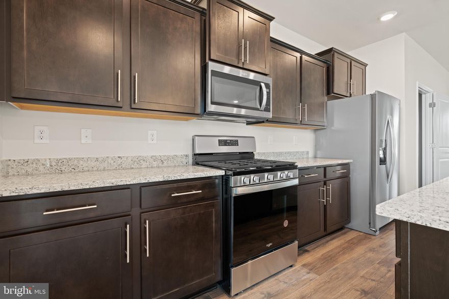 PARTIAL BRICK FRONT INTERIOR UNIT, AUGUST 2025 DELIVERY!  This 3-story open and contemporary floorplan that encompasses 4 bedrooms, 3.5 baths, and a 2-car rear load garage is STUNNING, and ready for a new homeowner this summer. Thoughtful design and modern luxury are uniquely embodied in this townhome plan, which features 1,763 sq ft of living space. It offers a spacious main level eat-in kitchen with espresso cabinets, recessed lighting, and a generous island providing plenty of cooking and entertaining space. The upper level boasts a private laundry closet and stylish primary bedroom, complete with a walk-in closet and dual vanities. The lower level features a finished 4th bedroom as well as a full bath. Hard surface flooring throughout the entire home offer modern luxury and contemporary appeal.  With black windows and a black garage, the curb appeal of this home boasts an urban and modern feel that is sure to stand out.  This specific home also boasts clear sight lines directly in front and behind the home, providing an excellent view free of obstructions.  Location within the community is also IDEAL with multiple guest parking spaces directly behind the home, and easy access to main roads leading in and out of the community.  Conveniently located across the street from tons of shopping and entertainment options. Incredible rates and closing incentive options available with the use of DHI Mortgage.