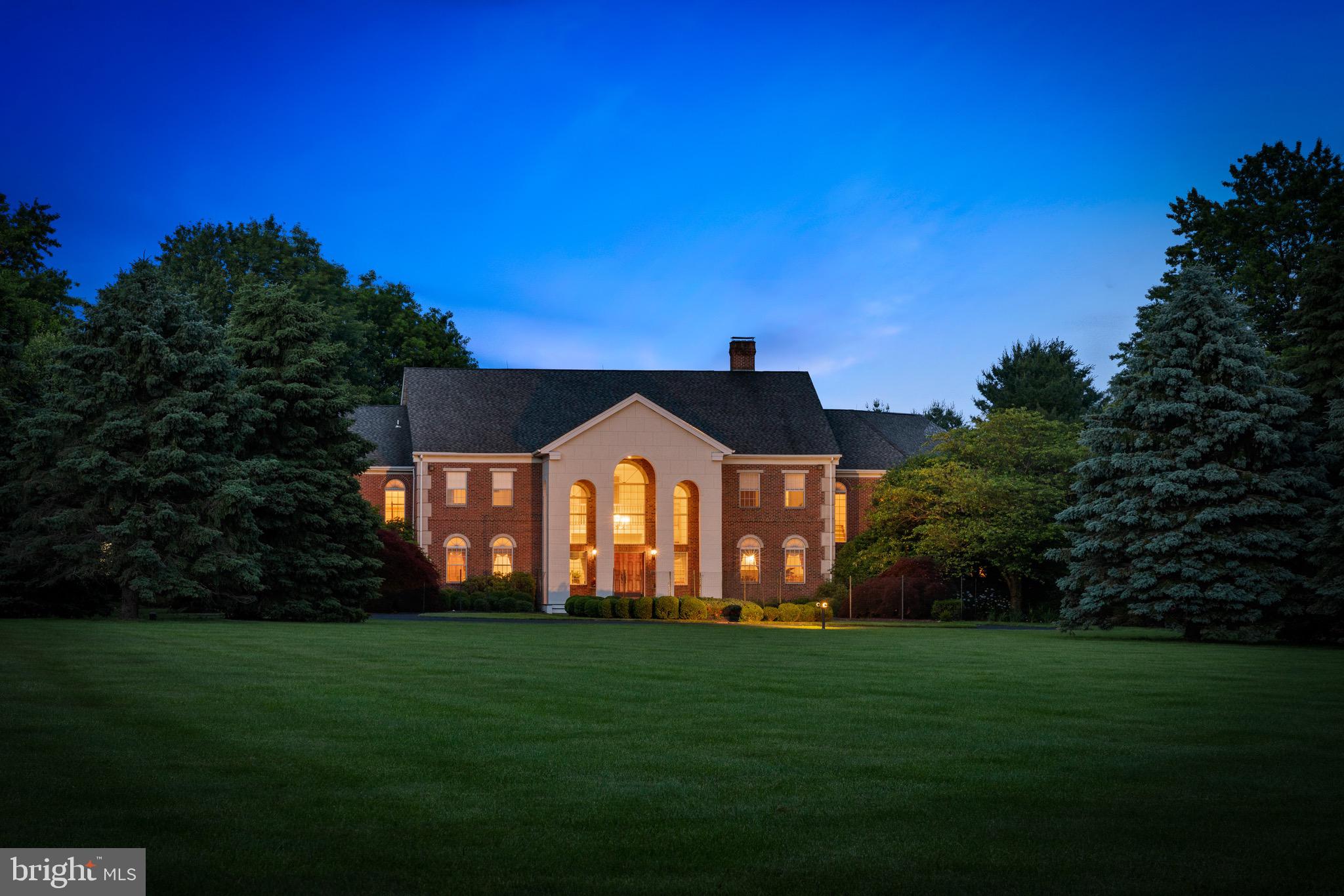 Welcome to Twin Oaks. This stately Georgian style all brick manor home gives homage to its namesake, an historic residence located in Washington DC. Situated at the end of a private enclave of only 9 estates on 90 acres in bucolic Upper Makefield, Twin Oaks encompasses 10 gorgeous acres and includes a private tennis court naturally fence by 100 arborvitae, expansive cedar deck and plenty of space inside for families of any size. You approach the home down a tree lined driveway and turn onto the double front drive for guests, to arrive at the impressively cantilevered front entry portico complimented by flowering specimen trees and lush greenery. Upon entering the double-door entry find the foyer flanked by grand double-butterfly staircases, lighted by a magnificent brass chandelier from the Bowery in NYC, and a view straight through to the 2-story great room with floor to ceiling fieldstone fireplace (1 of 4 in the home) and French doors to the large rear deck. On either side of the foyer you'll find the well-appointed formal living and dining rooms both entered via mahogany raised panel pocket doors and the study / library with floor to ceiling built-ins. The eat-in chef's kitchen is just off the great room and next to the butler's pantry, half bath and laundry rooms. The partially finished basement is massive and with double French door walk-outs, offers many options. In addition to the primary owner's suite which includes a dressing room, sun room, 2 walk-in closets, master bath and office / study, Twin Oaks offers 2 additional suites (1 on each level) perfect for in-laws, nanny / care-taker or guests. The remaining 4 bedrooms are upstairs and each complete with their own full bath and walk-in closet. A well-appointed spa room equipped with a sauna, steam shower and whirlpool tub complete the second level. At build, the homeowners spared no expense in ensuring that the best state of the art construction technologies were employed which is evidenced in the basement ceilings, foundation, utility rooms, 4-bay wide unobstructed garage and throughout many other areas of the home. Enjoy custom heavy wainscotings with 10' ceilings on the first floor, 9' on the second floor and 8'+ in the basement level. Recent 2019/2020 updates include a new central vacuum system with 10yr warranty, new Weil-McLain Cast Iron Boiler and 2 new additional HVAC systems. Served by blue ribbon Council Rock North HS and SF Elementary as well as nearby George School and Newtown Friends private schools, and privately tucked away on what was once rural farmland yet just minutes to Philadelphia, Princeton, King of Prussia and NYC, Twin Oaks truly is a Bucks County manor home estate built for the ages.
