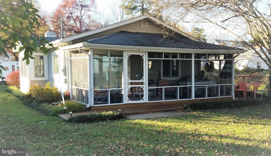 Grab your beverage and settle into your comfy chair on your screened-in porch and watch boats sail by.  This charming cottage on The Point, in the golf-cart community of Colonial Beach has a great water view and is just steps from the beach.  Not much farther is the bay where you can keep your boat in the quiet, protected waters of Monroe Bay.  This two bedroom, one and a half bath house is the ideal vacation getaway or permanent home.  It has been lovingly renovated and maintained and with a warm gas fireplace, is as cozy in colder weather as it is sporty in warmer weather.  The home also has a furnished and fun stand-alone trailer that has been used as guest quarters.  It can convey or be removed.  This house is not going to last.  Don't let this gem get away.