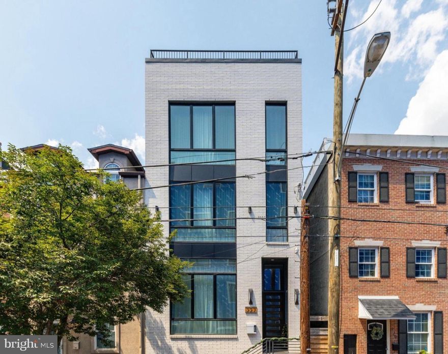 Architectural Elegance in the Heart of Fishtown – 227 E Allen Street

Discover elevated city living in this one-of-a-kind custom residence located in the dynamic Riverside/Fishtown district of Philadelphia. This four-bedroom, four-bathroom masterpiece blends contemporary design with premium craftsmanship, offering an unrivaled lifestyle across five thoughtfully designed levels—all seamlessly connected by a private elevator.

Step into the grand first floor where soaring 13-foot coffered ceilings and a dramatic gas fireplace wrapped in floor-to-ceiling tile set the tone for luxury. The open concept floor plan flows into a striking dining area with a lit tray ceiling, leading to a chef-caliber kitchen featuring high-end European cabinetry, integrated appliances, a built-in pantry with beverage center, and a dedicated coffee bar. Step outside to a private patio—ideal for al fresco dining and entertaining.

The second level hosts a spacious bedroom, full bath, custom dry bar with beverage center, and a stylish lounge area with an electric fireplace and custom shelving. The third floor features another spacious bedroom with a walk-in closet, hallway full bath, and a convenient wet bar. The luxurious primary suite is also located on this level, boasting a custom dressing room and a spa-inspired ensuite with a soaking tub inside a rainfall shower enclosure, LED-lit mirror, and dual vanities.

Take the elevator to the rooftop oasis—an entertainer's dream with panoramic skyline views, a pergola, gas and water hookups, and built-in audio for seamless indoor-outdoor living.

The fully finished basement expands your living space with a fourth bedroom, designer full bath, home theater/workout area, and yet another wet bar—perfect for game nights or hosting guests.

Additional features include built-in Sonos audio throughout, premium lighting upgrades, and a 10-year full tax abatement (approx. through 2031). Square footage and taxes to be verified by buyer.

Ideally situated near the vibrant scenes of Fishtown and Northern Liberties, with easy access to major routes like Delaware Avenue, this home offers unmatched urban convenience and quiet luxury.

Too many custom touches to list—this is a must-see.

Schedule your private tour today. Contact R.J. Timlin a