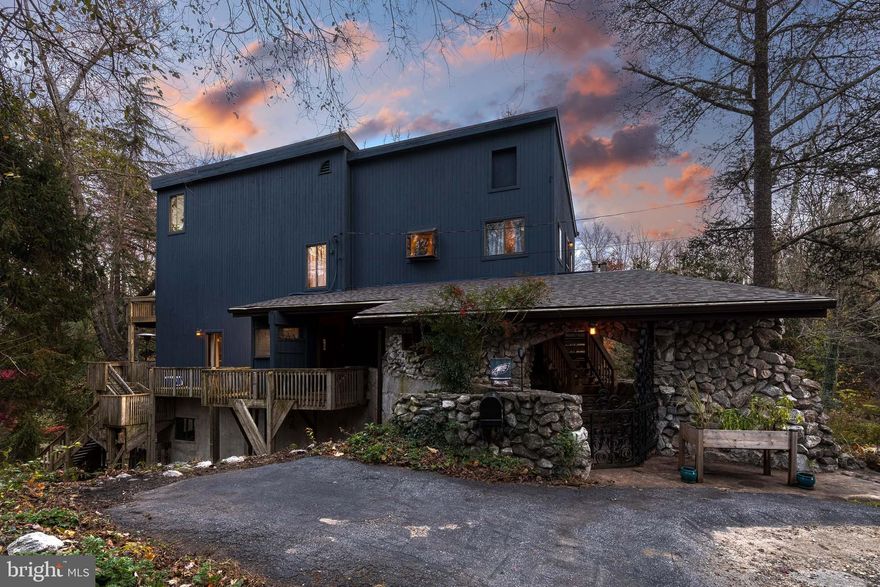 Tucked away at the end of a quiet street, this one-of-a-kind 4-bedroom, 2-bath home in Parkville feels like a private wooded retreat surrounded by a colorful tree line. The exterior features striking blue-painted cedar and stone, while the interior showcases a warm log cabin style with vaulted ceilings, skylights, recessed lighting, and hardwood floors and walls. The main level offers an open living room and kitchen with updated quartz countertops, island seating, and access to the back deck, perfect for entertaining. The primary suite includes vinyl plank flooring and an updated full bath with a beautifully tiled stall shower. Upstairs, you’ll find a gorgeous full bath with both a freestanding soaking tub & tiled stall shower, along with three spacious bedrooms, one with private deck access and another connected to the upper loft. The hallway boosts built-in bookshelves, a reader’s dream. The second upper level features a cozy open loft with wood floors and skylights, offering a peaceful spot to relax and take in the scenic tree line views. The lower level provides laundry and utility space. Enjoy the large, secluded backyard and recent updates including a new architectural shingle roof. Welcome Home!