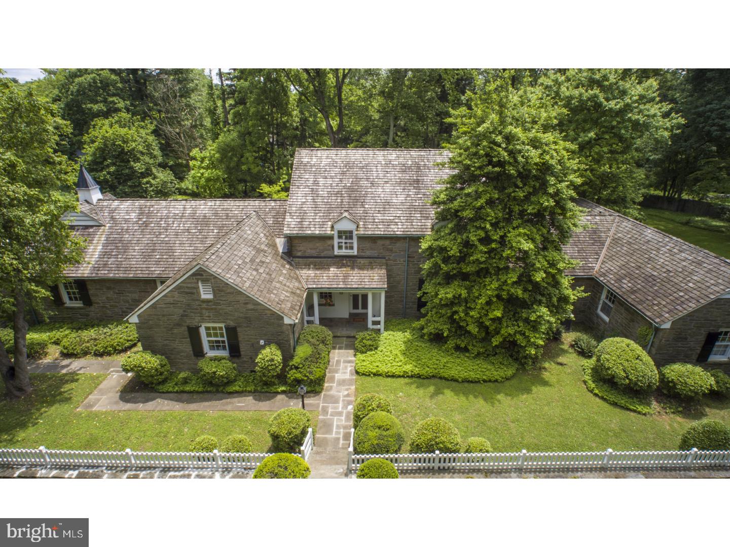 If you've always dreamed of living in a peaceful country estate without losing your connection to the city's cultural and other attractions, this exquisite property may be your dream come true. The centerpiece is a 1935 stone Colonial Revival house designed by R. Brognard Okie, one of the most talented and successful interpreters of the vernacular architecture of America's Colonial past. Okie's signature style is apparent in the the beautiful millwork, random-width pegged oak floors, natural wood-paneled library and in the way the buildings are gracefully nestled within the landscape. The first floor features a lovely entry hall, living room with fireplace, formal dining room, library with fireplace, large eat-in kitchen, breakfast room, powder room, master bedroom and 2 other bedrooms, all with en-suite bathrooms. On the second floor are 2 more spacious bedrooms with a shared bath, and a large attic storage area. The property includes a beautiful in-ground pool, tennis court, and a large carriage house with a wonderfully retro game room with fireplace, shuffleboard court and 2 bathrooms. There are 2 parking spaces in the attached garage and 2 more in the carriage house. The gorgeous, almost 3-acre lot has lush landscaping with many perennials and specimen plantings. Ideally located on one of the prettiest roads in Whitemarsh, minutes from Chestnut Hill's shops, restaurants and commuter train, steps from the Wissahickon Watershed's Green Ribbon Trail, and just down the road from the Philadelphia Cricket Club's Wissahickon golf course & clubhouse.