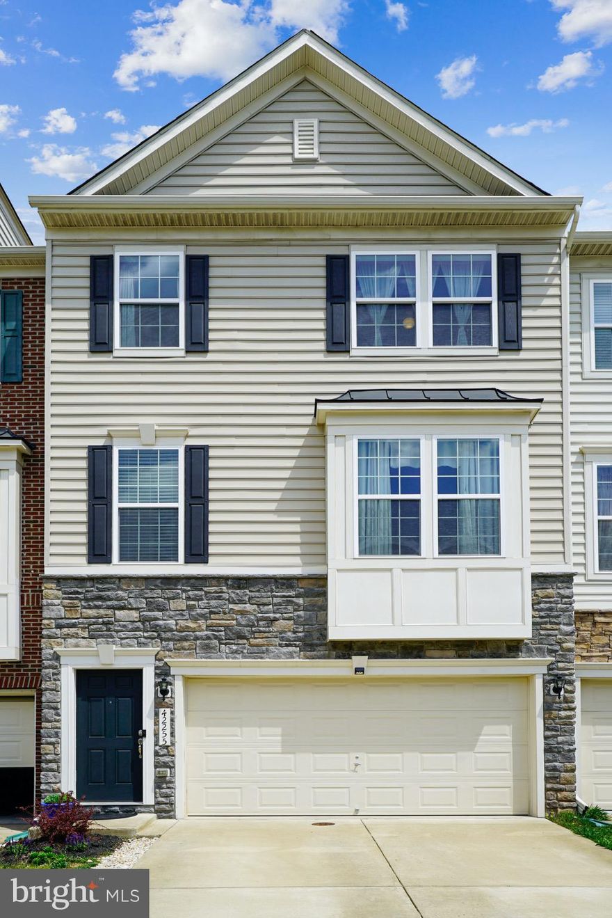 At the crossroads of Chantilly and Aldie, where bustling Northern Virginia and rolling countryside connect, this stone-clad townhome awaits, offering sunny spaces wrapped in idyllic suburban living. A Keagan model boasting a three level extension, this thoughtfully designed 2,650 square foot home offers two-car garage and space-enhancing bump outs. Inside, hardwood floors, high ceilings, and handsome trim add character to a thoughtfully open floor plan, while enviable positioning allows access to backyard community play space. While the gourmet kitchen features high-end appliances, endless cabinetry, and a granite-topped island for displaying party-perfect bites, enjoy dining and casual weeknights in the adjacent great room. In the sunlit sitting room, sip morning coffee and consider plans for your dream deck, while downstairs bonus space is a haven for relaxing, exercise, and walk-out access to the yard. With three window-filled bedrooms and three and a half soothing baths, enjoy easy living near shops, dining, and proximity to route 50 and Loudoun County Parkway. From here travel to entertainment and commuter points east, and head west to wineries, historic towns, and outdoor adventure.