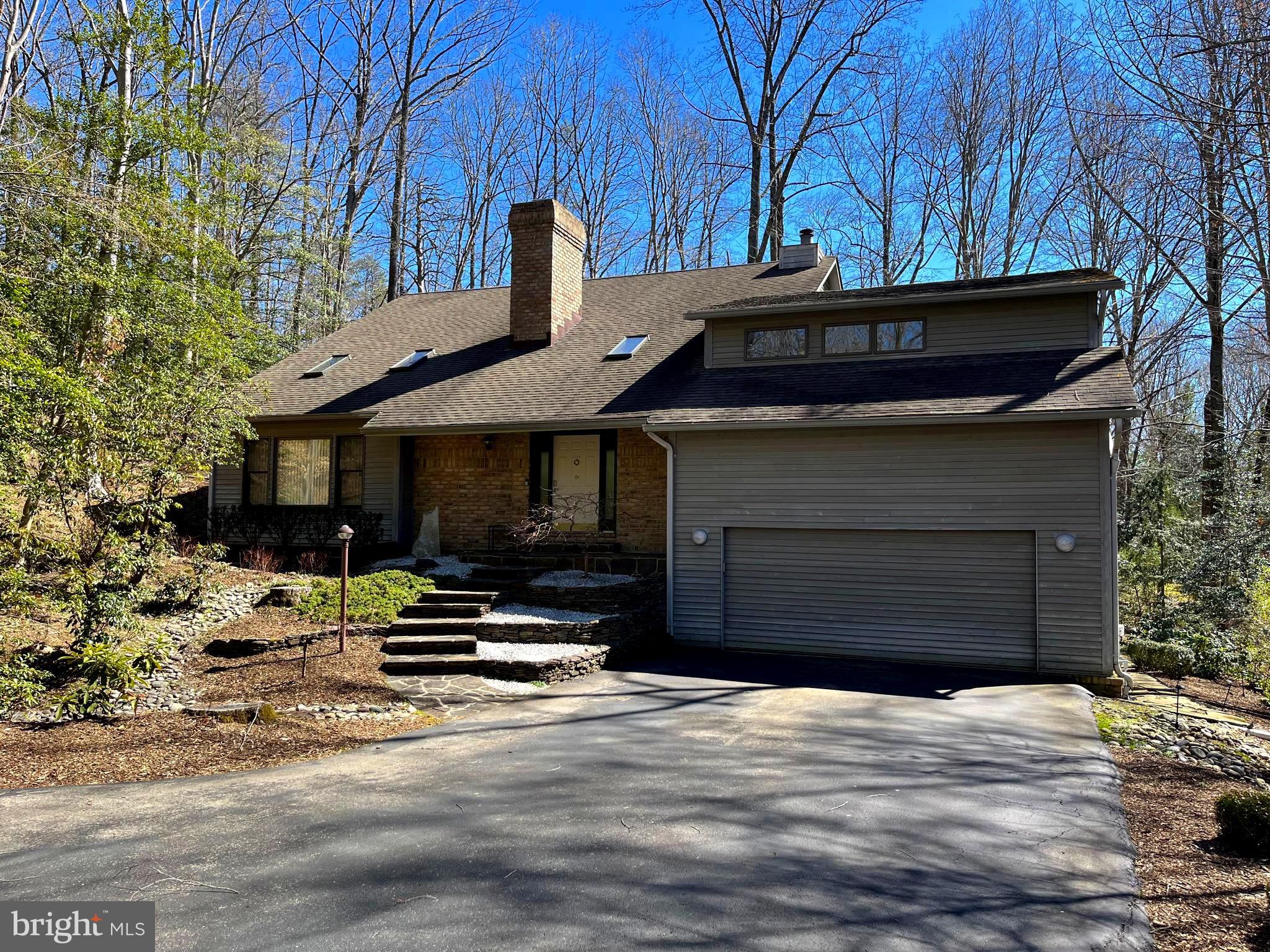 Stunning custom contemporary in the highly sought after Huntington Woods community. This privacy lover’s dream is nestled on 1.13 acres of low maintenance wooded oasis. This home offers it all, an open floor plan featuring vaulted ceilings, skylights, and beautiful hardwood floors throughout. Updated kitchen with custom cabinetry, granite countertops, stainless steel appliances, built in wine cooler, commercial grade gas range, and a massive island. The living room showcases one of two fireplaces with a beautiful feature wall. Step outside to the large back deck and stone terrace for a quiet escape and complete privacy. Finished basement offers endless potential for customization. Additional features include main level master with walk-in closet and large bathroom, formal dining room, large family room, updated alarm system with outdoor motion detectors, two car garage, and beautiful landscaping. This must see home also offers some of the highest rated schools in Anne Arundel County! Do not miss the opportunity to make this dream home YOURS!