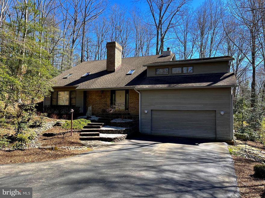 Stunning custom contemporary in the highly sought after Huntington Woods community. This privacy lover’s dream is nestled on 1.13 acres of low maintenance wooded oasis. This home offers it all, an open floor plan featuring vaulted ceilings, skylights, and beautiful hardwood floors throughout. Updated kitchen with custom cabinetry, granite countertops, stainless steel appliances, built in wine cooler, commercial grade gas range, and a massive island. The living room showcases one of  two fireplaces with a beautiful feature wall.  Step outside to the large back deck and stone terrace for a quiet escape and complete privacy. Finished basement offers endless potential for customization. Additional features include main level master with walk-in closet and large bathroom, formal dining room, large family room, updated alarm system with outdoor motion detectors, two car garage, and beautiful landscaping. This must see home also offers some of the highest rated schools in Anne Arundel County! Do not miss the opportunity to make this dream home YOURS!