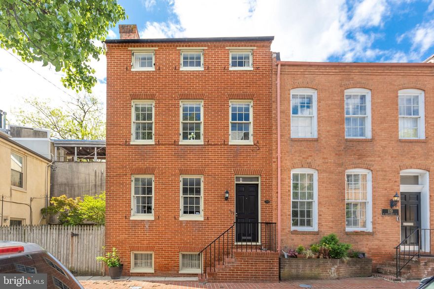 Nestled in the coveted Otterbein neighborhood, this circa-1820 3-story rowhome offers a rare blend of historic charm and modern livability. Boasting 2 bedrooms plus a loft, and 1.5 baths, the home is filled with character at every turn. Wide-plank original hardwood floors, exposed brick accents, and a cozy wood-burning fireplace create a warm, inviting atmosphere. Sunlight pours through oversized windows with deep sills, highlighting the freshly painted interior, open staircase, and thoughtfully integrated built-ins, including a custom bookcase. The open kitchen features stainless steel appliances, a built-in dining banquette, and French doors that lead to an expansive brick patio and private garden oasis—complete with low-maintenance turf, ideal for entertaining or quiet evenings outdoors. Upstairs, the third-floor loft provides flexible space for a home office, studio, or guest retreat, with direct access to a private balcony. Located in one of Baltimore’s most desirable and well-preserved historic communities, this home boasts a walkability score of 93 and unbeatable convenience to the Light Rail, MARC, downtown, Federal Hill, Camden Yards, and M&T Bank Stadium. Bonus: a valuable Otterbein pool bond also conveys with the sale.