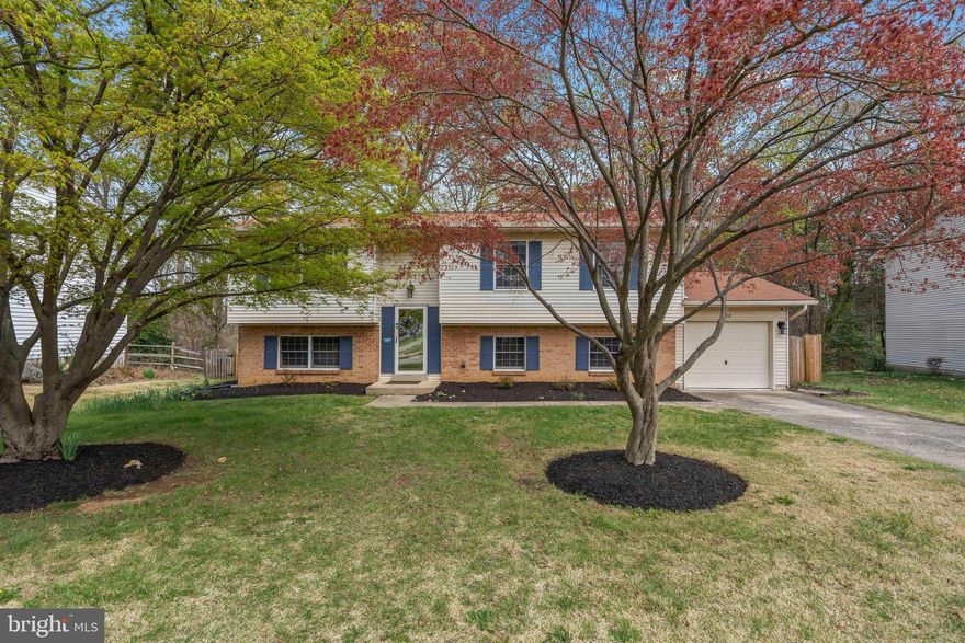 Located on a large lot with thriving landscaping that backs to serene woods, this move-in ready home is just waiting for you to enjoy the summer! The attached garage not only keeps your car pollen free, but offers an ideal place to store your bikes and recreational gear. This well-maintained split foyer home has plenty of living and entertaining space with beautiful wood floors in the living and dining rooms. The kitchen sparkles with new appliances and a peaceful view of the trees—making meal prep a delight. Downstairs, the welcoming family room and lower level provide plenty of room for everyone to unwind. Whether you're curling up by the wood-burning fireplace on chilly evenings or hosting a fun movie night, there’s space for it all. The bonus room - currently used as a home gym - gives you plenty of flexibility for a home office, keeping fit, or keeping toys out of sight. A lower level bedroom and half bath gives guests a bit of privacy.  Out back, relax on the patio and enjoy peace of mind with recent updates including a newer roof and water heater (2021), plus a brand-new wood privacy fence—perfect for keeping pets and kids safe while you enjoy the outdoors. The well-located, charming neighborhood is close to some of your favorite stores and restaurants, and there's easy access for commuters to the Beltway and the Huntington Metro. Just a few minutes away, enjoy the nearby trails in Huntley Meadows Park or all the fun of Franconia Park's water play area, tree house and carousel!