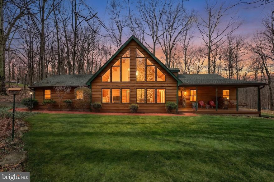 This unique 3-bedroom, 2.5-bath home tucked among the trees not far from Codorus State Park and close to the PA/MD line is truly one of a kind!  With its iconic soaring lines and warm wood accents, the feel is both timeless and inviting from the moment you arrive.  Artfully crafted from a log cabin design, this home features: 2x6 exterior construction, cedar siding, knotty pine interior, large stunning wood windows, a Quadrafire woodstove with glass front & stainless-steel liner, new HVAC main unit, 50-yr architectural shingles and more. Conveniently located on the main floor just off the great room, the primary bedroom has a private full bathroom and laundry. The large front porch is perfect for morning coffee, and quiet evening meals can be enjoyed on the rear deck with plenty of shade. Generator included. 2-car attached garage.  Located within  1 mile from the Manheim Adventure Park and a short drive to restaurants, shopping and more.  An adjoining 2.491-acre parcel with completed perc can be purchased by the buyer of this property for an additional $130,000.  If you've been searching for a home that feels like an escape without sacrificing comfort, this one is a must see!