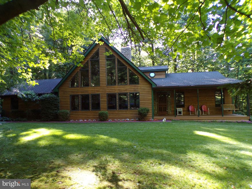 Your next retreat could be this beautiful 3-bedroom, 2.5-bath home tucked among the trees not far from Codorus State Park and close to the PA/MD line.  With its iconic soaring lines and warm wood accents, the feel is both timeless and inviting from the moment you arrive.  Artfully crafted from a log cabin design, this home features: 2x6 exterior construction, cedar siding, knotty pine interior, large stunning wood windows, a Quadrafire woodstove with glass front & stainless-steel liner, new HVAC main unit, 50-yr architectural shingles and more. Conveniently located on the main floor just off the great room, the primary bedroom has a private full bathroom and laundry. The large front porch is perfect for morning coffee, and quiet evening meals can be enjoyed on the rear deck with plenty of shade. Generator included. 2-car attached garage.  An adjoining 2.491-acre parcel with completed perc can be purchased by the buyer of this property for an additional $130,000.  If you've been searching for a home that feels like an escape without sacrificing comfort, this one is a must see!