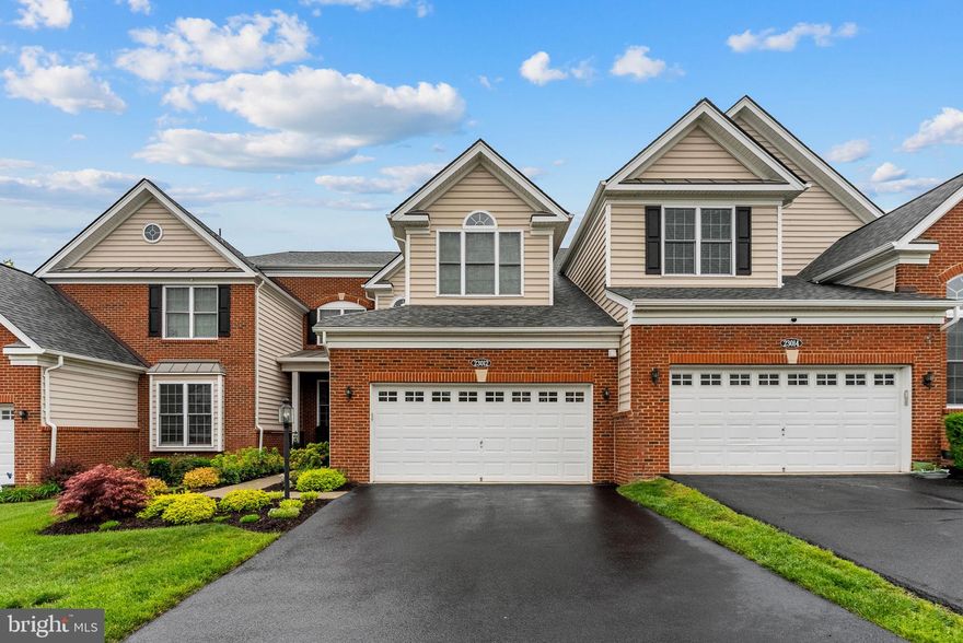 Welcome to this beautifully maintained carriage-style home located in the highly desirable Loudoun Valley Estates II community near Brambleton. Thoughtfully designed with spacious living areas, elegant finishes, and a versatile floor plan, this home offers the perfect blend of comfort, functionality, and lifestyle living.

Step inside through the welcoming foyer and into the expansive main level featuring rich hardwood flooring throughout. The main level offers a formal living room, elegant dining room, convenient half bath, laundry room, and a spacious primary suite conveniently located on the main level. The luxurious primary bathroom features dual vanities, a soaking tub, walk-in shower, and generous closet space.

The updated kitchen (2024) showcases upgraded cabinetry, quartz countertops, stainless steel appliances, double ovens, gas cooking, tile backsplash, and a large center island with seating. The kitchen opens seamlessly to the stunning two-story family room filled with natural light from dramatic floor-to-ceiling windows and centered around the updated fireplace completed in 2024.

The upper level features two generously sized bedrooms, two full bathrooms with tub/shower combinations, and a large open loft area overlooking the family room below. The loft provides the perfect space for a home office, study area, media room, or additional flex living space.

The fully finished lower level provides an expansive recreation area with plush carpeting along with rough-in plumbing already in place for a future bar or secondary kitchen setup, offering tremendous flexibility for future customization.

Additional major updates include a new roof (2024), new heat pump (2025), new water heater (2023), and new window screens (2024).

Outside, enjoy beautifully landscaped grounds, private patio area, elegant black aluminum fenced rear yard, and an attached garage with garage door opener for added convenience and storage.

Residents of Loudoun Valley Estates II enjoy exceptional HOA amenities including access to 3 community clubhouses, 3 swimming pools, 3 fitness centers, multiple playgrounds, walking trails, tennis and basketball courts, and beautifully maintained common areas.

Ideally situated just minutes from Brambleton Town Center, Dulles Landing Shopping Center, and major commuter routes including VA-267 Dulles Greenway, Claiborne Parkway, the Ashburn Silver Line Metro Station, and Washington Dulles International Airport. This home offers the perfect combination of luxury, convenience, and community living in one of Brambleton’s most sought-after areas.
