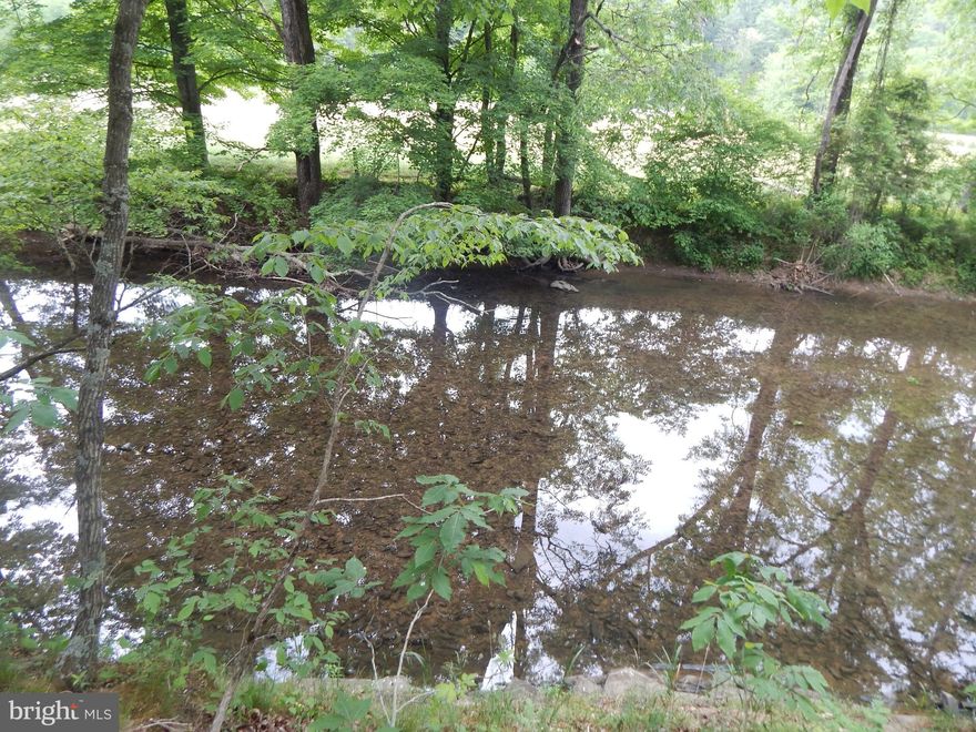 Price reduced! A beautiful 3.46 acreage lot fronting the Little Cacapon River. Over 350' frontage, level lot Most of the lot is out of the 100-year floodplain. A 4-bedroom ElJen septic system installed. Well installed.  Electric. Shed on the property. 
Lot is located on the right side of the road near end of road.  HOA dues to maintain roads and common ground w/picnic pavilion along the river.