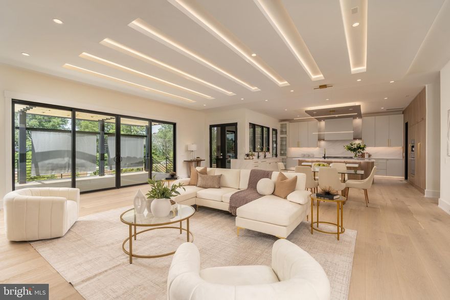 Experience elevated living in this luxury new construction architectural gem—where thoughtful design, luxury finishes, and a prime location just steps from Westwood Country Club come together seamlessly. Designed with entertaining in mind, this home offers the perfect setting for hosting everything from large celebrations to intimate gatherings with ease and elegance.
A dramatic two-story foyer welcomes you into over 7,450 square feet of artfully crafted living space featuring 7 bedrooms and 6.5 bathrooms. The open floor plan flows effortlessly through formal and informal living areas, highlighted by 10-foot ceilings, expansive picture windows, and warm wide-plank hardwood floors throughout the main level. The chef’s kitchen is a true showstopper—complete with a 9-foot center island. For easy everyday living there is a supplemental culinary food prep with a large sink, serving counter, built-in cabinetry and a second dishwasher. Miele appliances, a 60-inch side by side refrigerator, a built-in plumbed coffee station, and a separate butler’s pantry, all beautifully designed for everyday living and effortless entertaining.
The family room features a sleek ceiling design with integrated tape lighting, a linear gas fireplace with passive heat flow, and a wall of windows that open to a massive deck with a trellis-style ceiling and shades—creating a seamless indoor-outdoor experience for guests. There is also a screened porch which is accessible from the kitchen, family room and the deck.  Round out the main level is a secondary suite that can be used as an office or bedroom, adding to the versatility of the home's layout. Completing the main level is a spacious three-car tandem garage equipped with two EV charging outlets.
The open staircase, detailed with custom Poplar wood partitions, is a design centerpiece leading to the second level where you are greeted by a spacious informal living area. The primary suite is a luxurious retreat featuring its own heating and cooling system, two walk-in closets, a spa-inspired bath, and a private sitting room with fireplace—ideal for ideal mornings or unwinding at the end of the day.  Three additional spacious bedrooms each with its own bathroom and ample closet, and one with balcony for outdoor enjoyment.
The sprawling lower level features a stunning recreation area with a wet bar and a media room. Additionally, there are two flexible rooms that can serve as bedrooms or an exercise space, along with a full bath. French doors provide access to a covered patio, ensuring privacy and comfort for guests or multigenerational living.
Situated in a new, private six-home cul-de-sac with no HOA, across from the golf course —walkable to shops, Whole Foods, restaurants, and coffee spots, bike path, and minutes from Tysons Corner and Metro access. With standout design and a layout built for entertaining, this home delivers an unmatched lifestyle in one of Vienna’s most desirable locations.