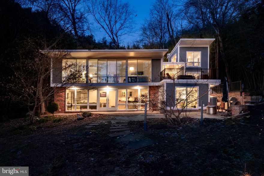 This gorgeous Mid-Century modern home designed by Charles Goodman, nestled in the highly sought-after Hollin Hills, boasts two impressive additions, including a recent three-story expansion. This new addition includes a spacious in-home office with exposed brick wall, a large storage room, and a gym/sitting room connected to the primary suite. A spiral staircase leads to a sunlit third-level room, offering spectacular treetop views. The gourmet kitchen is a chef’s dream, featuring high-end custom NEFF cabinetry, granite countertops, a professional Viking range, and a Sub Zero refrigerator. The dining room is enhanced with cork flooring and features a hidden bookcase that leads to a storage room. The main level includes a guest bedroom with a built-in Murphy bed, perfect for hosting visitors, while the entire home offers abundant storage options. Expansive, floor-to-ceiling double-pane windows flood the space with natural light. The upper level is home to a vast living room with vaulted ceilings, a wood stove fireplace set against an original slate mantle, and glass doors leading to a new Trex deck. Two additional guest rooms and a newly remodeled guest bathroom with an exposed brick wall complete the upper level. The expanded primary suite features a custom walk-in closet, vaulted ceilings, and glass doors that open to the Trex deck. The sunlit primary bathroom offers a luxurious jacuzzi tub and a separate shower. Situated on a half-acre, secluded lot, the property is beautifully landscaped and includes a greenhouse, along with various patios and decks perfect for outdoor entertaining.  One of Hollin Hills premiere properties, tucked into nature.