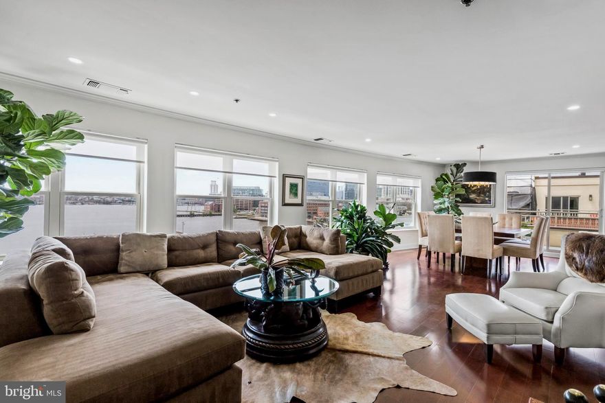 Price Adjustment!  Renovated penthouse with compelling views in historic Fells Point . This extraordinary direct waterfront residence boasts approximately 2,300 sq. ft. of prime urban living space.  The home is positioned strategically on the water side of the building to capture stunning views of the Harbor, historic Fells Point, Sagamore Pendry, and the city-scape from the living areas and the expansive balcony.  The condominium has been beautifully remodeled with luxury materials, detail, and finishes.  The welcoming marble-floored foyer and generously sized hallway are perfect for the display of art.  The spectacular wall of windows with sweeping views provides the perfect backdrop for the dramatic, spacious living-dining and kitchen.  The beautiful open  living area features gorgeous hardwood flooring, a wood burning fireplace, dining area opening to the balcony, sleek kitchen and bar/prep area.  The kitchen features stainless steel appliances and unique granite countertops.  The sprawling island is perfect for casual gatherings or quick evening meals.  Adjoining the kitchen is a custom built-in bar. A handsome den with natural light from the skylight is conveniently located across from the kitchen.  The en-suite primary bedroom and bath are fabulous.  The generously sized bedroom has balcony access, designer carpeting, a skylight for additional natural lighting, and a huge walk-in closet/dressing area.  The recently renovated primary bath is sumptuous with marble shower, flooring, and custom floating vanity.  The second en-suite bedroom is light-filled with a wall of windows and designer carpeting.  The adjoining large bath has a tub-shower and marble flooring. A powder room and utility/laundry room are conveniently located off the hallway.  Additional highlight of the property include replacement windows and sliders, custom window shades,  all new overhead LED recessed lighting, and two-zone heating and cooling. The generous-sized balcony overlooking the water is perfect for entertaining, displaying prized plants or just relaxing. Firework displays, sailboat races, and ships can be enjoyed from various rooms and the sprawling outdoor space.  Two unassigned garage parking spaces are provided.  Building amenities include:  24 hour front desk staffing, security cameras, an outdoor pool overlooking the Baltimore Harbor, a fantastic exercise room, elegantly appointed lobby, two landscaped elevated community courtyards, three elevators, brick and synthetic stucco exterior, smoke detectors and sprinklers.  BeltÃ¢ÂÂs Landing is located close to Downtown Baltimore, Harbor East, the Inner Harbor, Johns Hopkins Hospital, U of M campuses, institutions, train stations, the Stadiums, and major highways.  Shopping, cultural activities, restaurants, and bars are all within walking distance.