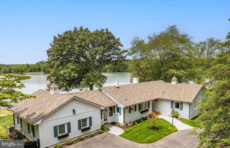 Coastal Point Perfection – A re-imagined, fully furnished, and turn-key, short-term rental, second home, or primary residence waterfront retreat opportunity within walking and biking distance of the Town of Saint Michael's. Tucked at the end of a private, tree-lined lane and wrapped in over 700 feet of panoramic waterfront, this exceptional property has been completely transformed from its 1965 brick ranch origins into a timeless coastal cottage retreat. Positioned on a prime point of land, this home offers the ultimate in privacy, waterfront lifestyle, and design sophistication.  The exterior has been thoughtfully appointed with new board-and-batten siding, an architectural shingle roof, half-round gutters, and authentic shutter hardware, creating a charming coastal aesthetic that blends seamlessly with its natural surroundings. A circle driveway welcomes you home, while the fenced grounds feature an array of outdoor amenities, including a new pier with a 10,000 lb boat lift, a heated in-ground saltwater pool with retractable safety cover, and a custom two-story accessory building for storage, hobbies, or workshop use.  Inside, the home impresses with a vaulted, open-concept floor plan that combines comfort and coastal elegance. At its heart is a chef-inspired kitchen with honed granite counters, professional-grade appliances, and a seamless flow into airy dining and gathering spaces—perfect for entertaining or quiet waterfront living.  This spacious retreat offers four beautifully appointed bedrooms, including options ideal for an in-law suite or home office, thanks to a separate private entrance that enhances flexibility. Each of the four full bathrooms and the stylish half bath has been fully renovated and constructed with a designer’s touch, blending crisp finishes and modern comfort throughout. Nearly every system has been updated, including all-new HVAC and mechanical systems, ensuring peace of mind for years to come. The home is also offered fully furnished with magazine-quality interiors, making it a true turnkey opportunity—whether as a private escape, family compound, or income-generating licensed short-term rental.  Experience the perfect blend of waterfront luxury, thoughtful design, and effortless living—this is the coastal lifestyle, redefined.  The property is currently licensed as a short-term rental (STN-24-10).  Property also has an Offshore Duck Blind and Shoreline License ( #16488). Furnishings are included in the sale.