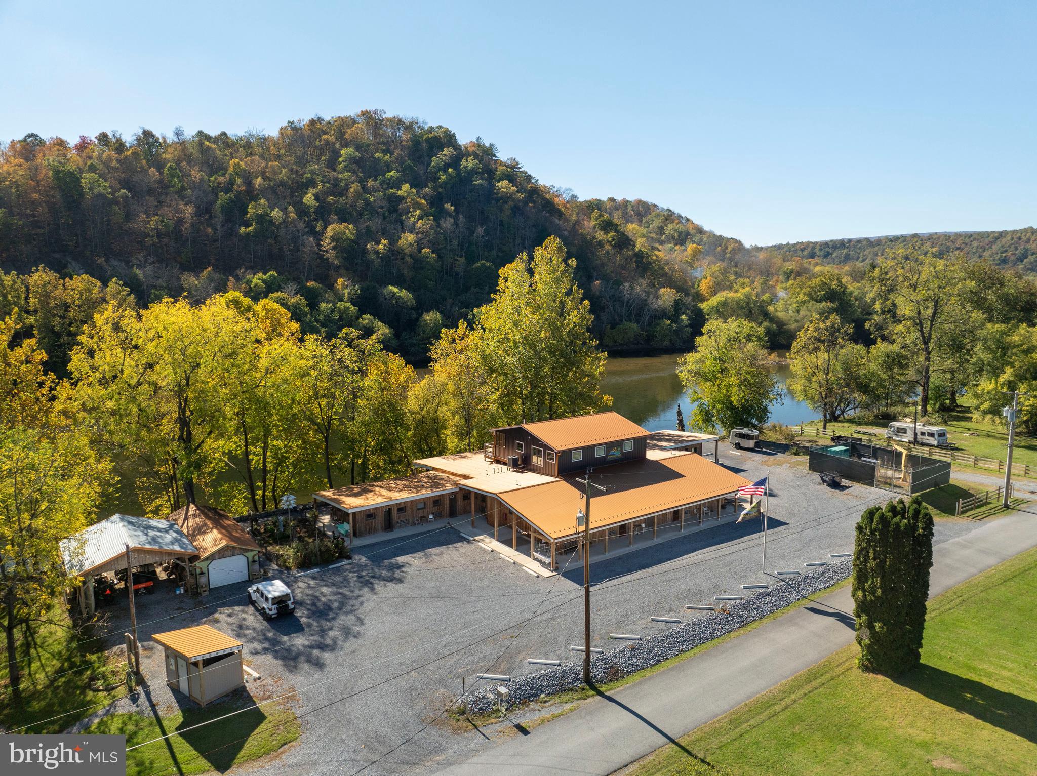 Originally built in 1954 and fully revitalized in 2022 after two decades of vacancy, this popular resort is a serene escape nestled along 650 feet of private Juniata River frontage. Now considered new construction, over 90% of the resort has been rebuilt to modern code, with the addition of a second story Host’s Loft - ideal for a private residence or luxury rental, featuring a full sprinkler system. The boutique campground near the river is perfect for family getaways, while the adult-focused Guest Lodge provides abundant amenities and panoramic views.
The Lodge offers 12 well-appointed guest rooms: five with two queen beds, one ADA-compliant room with Twin XL beds, and six with king beds. Seven bathrooms have been completely renovated, while five preserve charming vintage tub/shower combos favored by returning guests. Six spacious, shaded riverfront camp lots provide 30A and 110A electric, fire rings, picnic tables, and access to a rustic, open-air shower house.
Seasonally open from May through September, the resort draws a growing guest base each year, attracted by its tranquil atmosphere. Amenities include riverside decks and steps, two fire pits, fishing pier, kayak/swimming launch, two shower houses, and a communal outdoor kitchen stocked with tableware and cooking essentials. Filtered water refill stations and 24/7 coffee and tea service enhance guest comfort.
Guests enjoy outstanding birdwatching, stargazing, and smallmouth bass fishing, along with popular kayak and tube floats. The resort welcomes visitors from major metro areas including Philadelphia, Pittsburgh, Baltimore, and Washington, D.C.
Opportunities for expansion include activating a hotel liquor license, adding restaurant service, introducing alternative lodging (yurts, treehouses, etc.), or developing event spaces for weddings and reunions. There's also potential for a coffee shop or bistro, and ample space for a pool or hot tub.
Included in the sale: a loyal guestbook, active Airbnb listing, integrated website with booking software, Facebook page, professional media (photos, videos, drone footage), and fully furnished, guest-ready rooms with linens, robes, toiletries, and dining sets.
Located adjacent to American Legion Country Club Golf Course and near local attractions like Raystown Lake, Amish Country, and East Broad Top Railroad, this resort is a turn-key opportunity with proven growth and unique appeal. Make your wildest dreams a reality; schedule a private showing today!