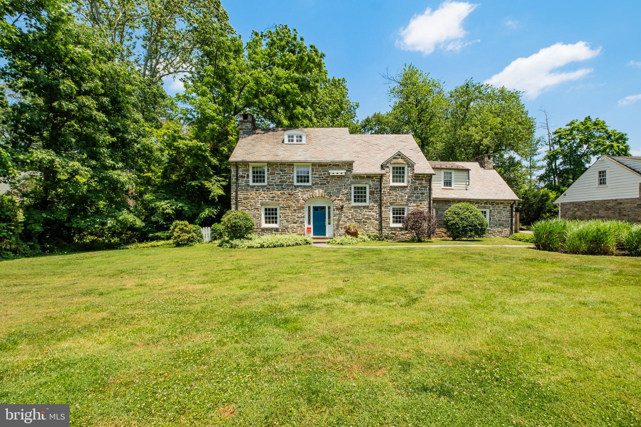 Showings Begin at the Open House on 6/29 12-3pm! Arrive on one of the most beautiful streets in Wynnewood, and visit this 1935 Stone Colonial home in the Lower Merion School District in an idyllic setting for serene evenings and entertaining. This charming home is in pristine condition, has many preserved original architectural details, and offers approximately 3500 sq ft of living space, with 6 bedrooms, 3.5 baths on a half acre wooded lot with a stream at the back of the property. The home sits back on the lot, with great curb appeal, ample play space in the front, and a private yard with woods and stream. Many top quality improvements in the past two ownerships including slate roof with copper gutters and downspouts, conversion of oil heat to gas, finishing of the basement, AC installation, bluestone sidewalk, resurfaced driveway, new side-yard fence and kitchen refurbishment. Enter the nicely sized foyer, home office with powder room to the right, living room to the left and formal dining room right in front of you. The large living room has a wood burning fireplace and patio doors that open to the lovely covered patio and steps to the stream. The comfortable dining room offers ample space for a large dining table, and the bay window adds lots of character to this room. To the right is the kitchen which also opens to a rear patio and is adjacent to the attached 1.5 car garage great for parking and storage. The second floor has a Primary Suite with en suite 4 piece bathroom, tastefully renovated with marble floor, attractive pedestal sink and freestanding clawfoot tub in addition to the shower. There are three additional bedrooms on this level and a shared hall bath. The third floor is a finished space with two bedrooms, a center hall bath and storage space. Walking distance to lots of restaurants, shops, commuter train, Suburban Square and so much more. This is the one you were waiting for, classic elegance, modern amenities and fabulous location.