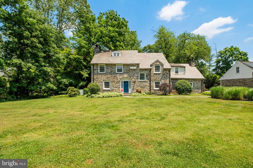 Showings Begin at the Open House on 6/29 12-3pm! Arrive on one of the most beautiful streets in Wynnewood, and visit this 1935 Stone Colonial home in the Lower Merion School District in an idyllic setting for serene evenings and entertaining. This charming home is in pristine condition, has many preserved original architectural details, and offers approximately 3500 sq ft of living space, with 6 bedrooms, 3.5 baths on a half acre wooded lot with a stream at the back of the property.  The home sits back on the lot, with great curb appeal, ample play space in the front, and a private yard with woods and stream. Many top quality improvements in the past two ownerships including slate roof with copper gutters and downspouts, conversion of oil heat to gas, finishing of the basement, AC installation, bluestone sidewalk, resurfaced driveway, new side-yard fence and kitchen refurbishment. Enter the nicely sized foyer, home office with powder room to the right, living room to the left and formal dining room right in front of you. The large living room has a wood burning fireplace and patio doors that open to the lovely covered patio and steps to the stream. The comfortable dining room offers ample space for a large dining table, and the bay window adds lots of character to this room. To the right is the kitchen which also opens to a rear patio and is adjacent to the attached 1.5 car garage great for parking and storage. The second floor has a Primary Suite with en suite 4 piece bathroom, tastefully renovated with marble floor, attractive pedestal sink and freestanding clawfoot tub in addition to the shower.  There are three additional bedrooms on this level and a shared hall bath. The third floor is a finished space with two bedrooms, a center hall bath and storage space. Walking distance to lots of restaurants, shops, commuter train, Suburban Square and so much more. This is the one you were waiting for, classic elegance, modern amenities and fabulous location.