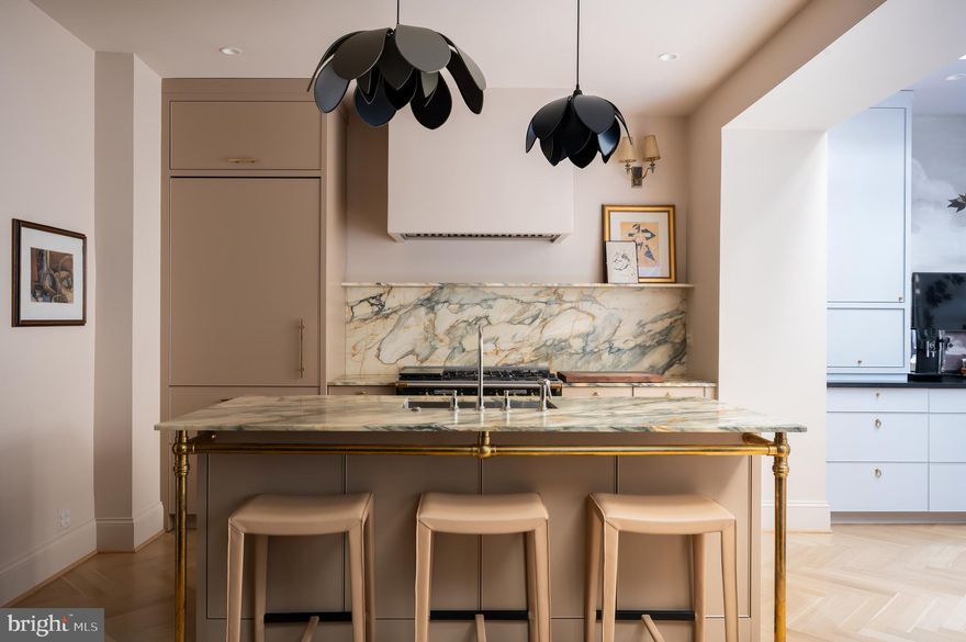 Prominently sited on a tree-lined block in the heart of prestigious Kalorama, 1829 23rd Street NW is a stately 1917 townhome meticulously infused from top to bottom with high style and painstaking workmanship. Proudly featured in Architectural Digest Italia, the home was inspired by its owners’ world travels and represents a masterful collaboration between a star-studded team comprising architect Christian Zapatka and Alisa Bloom Design. The home’s classic white brick and contrasting black trim facade is accented by a vibrant, jewel-tone blue front door, injecting a slight contemporary flair into a historic block. 

Stepping into the formal entry hall, the palette continues with paint-like French wallpaper complementing splendid alternating gray and black stone tiles on the floor. Formal living and dining rooms exude elegance. The former features a forward exposure via triple windows, with sensations of warmth established by the roaring fireplace and imported antique Italian marble mantle. The latter is central within the home, showcasing the stunning white oak herringbone floors, exquisite Forbes and Lomax switchplates, and substantial Baldwin hardware found throughout as a testament to the no-expenses-spared mentality of construction. 

The chef’s kitchen is a functional work of art, with a LaCanche dual fuel range nestled beneath a radiant marble slab backsplash and commercial-grade range hood. A full size SubZero refrigerator/freezer, Bosch dishwasher and Lefroy Brooks fixtures are all subtly integrated within furniture-grade inset cabinetry. An adjacent den offers French doors leading out to the garden, while the whimsical breakfast room features a built-in buffet, its custom glass ceiling letting in natural light to augment the nature scene on the walls. A powder room with Watermark fixtures and a violet marble vanity completes the main level. 

Three secondary bedrooms are found on the upper level, each evoking a distinct style and featuring ample storage. They share an exquisite full bath comprising Italian marble counters, Watermark fixtures, custom French shower doors, and a deep soaking tub with shower. The primary bedroom is tucked away on the top level for ultimate privacy. Its bedroom and sitting area are a sanctuary, accessing a large dressing room with full cabinetry and a center island. Further beyond is the spa-inspired primary bath. Lefroy Brooks fixtures, heated Waterworks tile floors, a freestanding tub, marble shower, and additional laundry facilities create a self-sufficient oasis. 

The lower level can be independently accessed from outside to enhance practicality. A fitness room with rubber floor, laundry center with additional appliances, mudroom, half bath, and generous storage space shape what is an amenity-rich home. Furthering the mission is a Crimpco security system with video surveillance and Sonos throughout. The sound system extends into the rear garden, designed by Cynthia Ferranto and consisting of a composite deck, Viking grill area, custom planters, and automatic irrigation. Walled-off privacy and string lights overhead create an ideal environment for outdoor entertaining or dining al fresco. 

A cosmopolitan Kalorama location enables easy access to parks, trendy eateries, shops, and transit – all within minutes. Thoroughly reimagined to the highest degree of tastes and standards, 1829 23rd Street NW is a true one-of-a-kind offering.