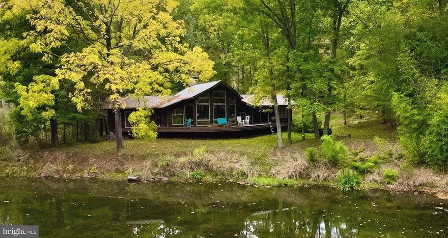 Enchanting riverfront cabin  on The Lost River with 1.56 Acres has all you could ask for in a vacation, rental property or a full time home.  The floor to ceiling windows provide spectacular views of Lost River and inside the spacious, airy, open floor plan with vaulted ceilings, and majestic stone fireplace is great for entertaining or relaxing.  Kitchen and baths recently renovated.,  Hardwood flooring in the great room and bedrooms, stone floors in foyer and baths.  Step out of primary bedroom onto the rear deck and watch the birds and fish The Lost River.  There are two other bedrooms one of which also has deck access.  Primary bath off of master has stone and glass block tub surround. Walk the grounds with wood carved bears and gargoyles and a serenity garden or relax by the firepit along the river. 
 Some furnishings convey.   GIS does not show correct location for this property.