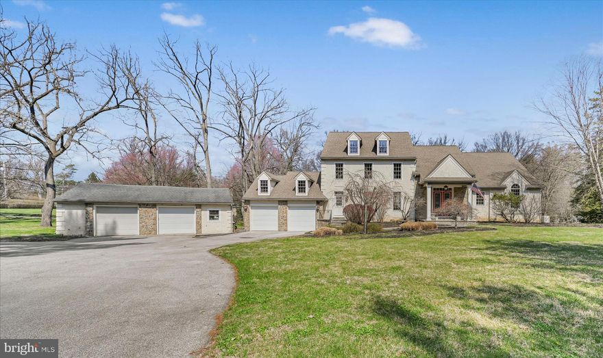 Set on a picturesque 1.8-acre lot with a tranquil creek and frequent visits from local wildlife, this custom-built residence offers a rare blend of craftsmanship, space, and natural beauty. Thoughtfully designed and meticulously maintained, the home welcomes you with a dramatic open entryway and rich Brazilian cherry hardwood floors that flow throughout the main level. At the heart of the home, the great room impresses with soaring vaulted ceilings and a striking wall of windows that flood the space with natural light while framing serene outdoor views. A double-sided gas fireplace creates a warm connection between the great room and the informal dining area, adding both charm and functionality. The kitchen is designed for both everyday living and entertaining, featuring an oversized island, granite countertops, two sets of sinks, one overlooking the backyard and then an additional deep sink, gas cooktop, double wall ovens, and a generously sized pantry, complemented by a separate wet bar for added convenience. A formal dining room with high end crown molding offers an elegant space for gatherings. The main-level primary suite is a private retreat, complete with vaulted ceilings, direct access to the deck, and an expansive custom walk-in closet. The ensuite bath showcases block tile details, a marble vanity, and a spacious tiled steam shower, creating a spa-like atmosphere. Upstairs, a custom-crafted handrail leads to a loft area and catwalk that overlook the main living space, enhancing the home’s open and architectural appeal. Four additional bedrooms provide flexibility, with one currently used as a sitting area or office. Comfort is ensured year-round with a three-zone gas forced air heating and central air conditioning system. The unfinished basement is exceptionally clean and offers future potential, with a nearly completed full bathroom already in place. Outdoor living is equally inviting, with a large deck ideal for relaxing or entertaining while enjoying the peaceful surroundings. Additional features include gutter guards and a whole-house Generac generator for added peace of mind. A standout feature of the property is the detached oversized two-car garage, previously used as a workshop, complete with its own heating, central air, and half bath—perfect for hobbyists, entrepreneurs, or additional workspace needs. To complete the offering, the seller is including a one-year home warranty, and new smoke and carbon monoxide detectors have been recently installed. This property combines thoughtful design, quality finishes, and a scenic setting to create a truly distinctive place to call home.