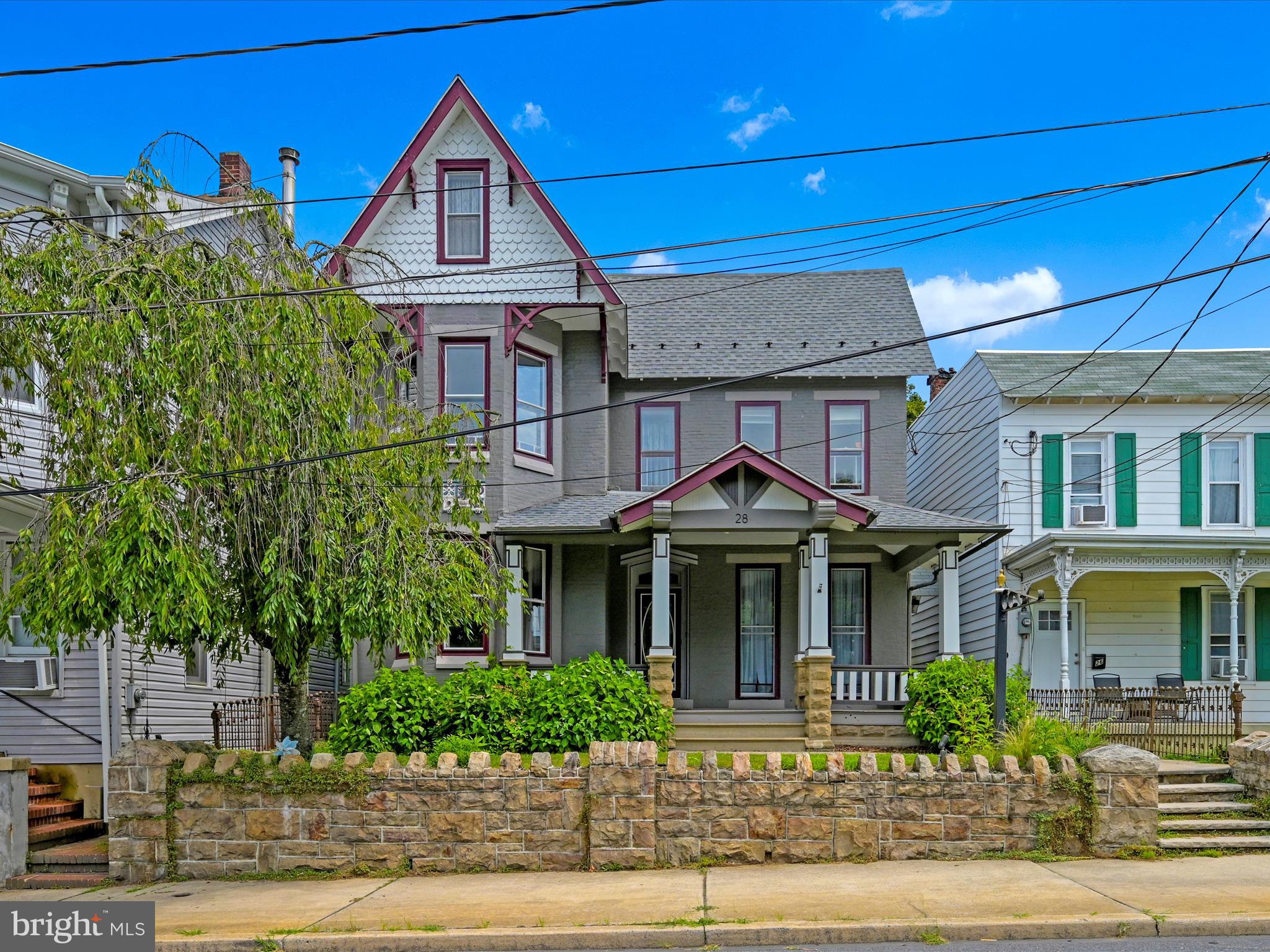 Welcome to this beautifully maintained Victorian home located in the desirable Schuylkill Haven area. Zoned R-2, this property offers a unique opportunity to enjoy both residential living and professional office space. Used as a single-family home and an accounting office for over 30 years, it is ideally situated just outside the business district, within walking distance to the library, post office, pharmacy, grocery store, banks, and more. The inviting front porch, framed by blooming hydrangeas and wisteria, provides a front-row seat to community parades, fireworks, and annual Borough Day celebrations. Inside, the main foyer showcases original hardwood floors, high stunning ceilings, and preserved woodwork with a combed finish. The spacious living room features bay windows with original wooden shutters and a decorative fireplace, flowing seamlessly into the formal dining room through stunning 18-paned glass French swinging doors. The kitchen was fully renovated in 2020 with solid wood cabinetry, black stainless steel appliances, subway tile backsplash, open shelving, and black-and-white luxury vinyl plank flooring. A charming pass-through connects the kitchen to the dining room. The adjacent laundry room includes a vintage laundry tub, built-in folding table, tons of storage and would make a great mud room with outdoor access. Step out to the private backyard, complete with a patio, garden beds, white picket fencing, and off-street parking for four vehicles. A restored wrought iron gate provides side entry to this inviting outdoor space. The main level also features a dedicated office area with a separate exterior entrance, new carpet and fixtures (2019), and two large walk-out windows. This space includes an 8’ pocket door and offers flexible use as a home office, first-floor bedroom, gym, or additional family living area. A full bathroom with matching luxury vinyl flooring is located just behind the office. Upstairs, you’ll find four spacious bedrooms with wide-plank hardwood floors and beautiful details, including colored glass accents and bay windows. The full bathroom features a vintage-style pull-chain toilet and a clawfoot tub. A walk-in closet and original bonus closet offer generous storage. The third floor includes a finished bonus room with heat and carpeting, perfect for a fifth bedroom, den, or playroom. This home offers the perfect blend of historic character, thoughtful updates, and versatile functionality—all within a vibrant small-town setting. Don’t miss your chance to own this one-of-a-kind property. Schedule your showing today! **SELLERS WILL CONSIDER ALL LOAN PROGRAMS/TYPES**