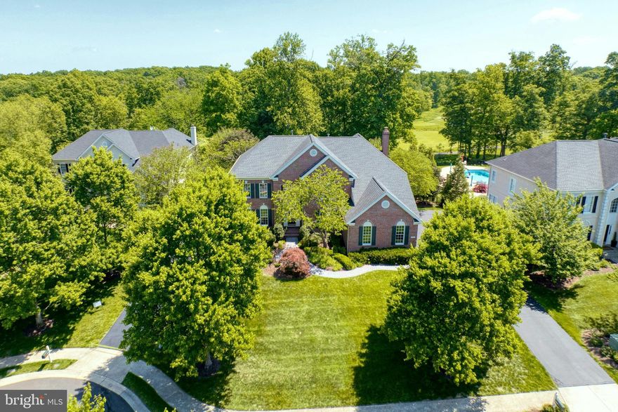 Welcome home to this stunning brick front Toll Brothers built home on a private .48 acre lot on a cul-de-sac street in the highly coveted gated Belmont Country Club golf course community of Ashburn. This beautiful home features 4 bedrooms, 4.5 baths, over 5600 square feet of indoor living space, fresh paint throughout much of the home & an incredible rear yard with trees backing to the golf course. Inviting two story foyer with curved staircase & detailed molding welcomes you as you enter this home. Spacious living room & formal dining room with detailed moldings & custom lighting. The gourmet kitchen was renovated in 2020 & features stainless steel appliances, upgraded quartzite countertops, tons of cabinet space, center island, pantry & spacious eating area. The grand two story family room features a wall of windows providing tons of light, new carpet, cozy wood burning fireplace & rear staircase. Private main level office with built-ins provides ideal work from home space. The main level also features a powder room & mudroom leading out to the oversized 3-car garage. Spacious primary suite features a luxurious renovated full bath & two walk-in closets. The secondary bedrooms all feature new carpet & includes bedrooms two and three with a shared updated bath as well as a fourth bedroom with private full bath. The finished lower level is an entertainer’s dream with multiple areas including a recreation room, pool table area, exercise area, custom bar with refrigerators, 4th full bath, media room & storage! The outdoor living space includes an incredible covered porch & deck overlooking the picturesque rear yard with trees & views of the golf course. This home has been meticulously  maintained by the original owners whom have updated the roof, water heater & upper level HVAC. The monthly HOA Fee includes lawn mowing, high speed internet, cable TV, trash removal, community swimming pool, playground & more. Belmont Country Club offers many social events & golf course memberships are available! This home is conveniently located nearly local dining, shopping, entertainment & commuter routes.