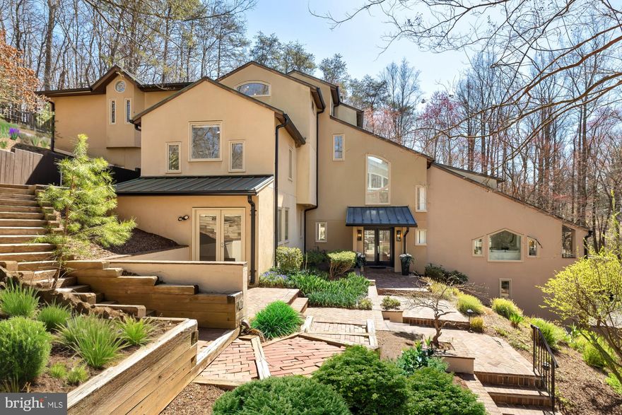 Nestled within a gated 3.09-acre sanctuary in McLean, 839 Towlston Road emerges as a remarkable testament to modern architecture and the legacy of Frank Lloyd Wright. Designed by Theodore “Ted” Dixon Bower, a distinguished alumnus of Wright's school, this residence is an embodiment of organic architecture harmoniously integrated with its natural surroundings. The home's striking contemporary design is a symphony of form and function, featuring a dramatic vaulted ceiling that spans the double-height foyer and formal living room. This architectural marvel is enhanced by large picture windows that frame the lush landscape, creating a seamless connection between the indoors and the tranquil sounds of the adjacent Rocky Run. The interiors of this masterpiece are a testament to functional artistry, featuring a flowing floor plan that bathes each space in natural light. At the heart of the home, the chef's kitchen, renovated in 2019, boasts marble and glass countertops, natural wood cabinets, and top-of-the-line appliances, adjacent to a sun-lit solarium and formal dining room that provide elegant spaces for entertaining. Comfort and privacy are paramount, with a cozy den and guest suite completing the main level. The upper level unfolds as a haven of relaxation, where a loft-style sitting area with a gas fireplace and vaulted ceilings invites serene moments. Each bedroom offers an en suite bathroom and premium amenities, while a private office and library cater to both work and leisure. The crown jewel of this residence is the primary suite, occupying the entire top level with a private fireplace, sitting room, and balcony that commands unobstructed views. Its skylit bathroom serves as a spa-like retreat, featuring dual vanities, twin walk-in showers, and a jetted tub set against a backdrop of the serene landscape. The property's exterior is a masterpiece of hardscaping, with multiple tiers creating a private natural paradise. 839 Towlston Road is not just a home; it's a living piece of art that carries the legacy of Frank Lloyd Wright's architectural principles. This one-of-a-kind offering is a rare gem in McLean, perfect for the most discerning buyer seeking a unique blend of history, architecture, and modern luxury. ***Offers, if any, will be due on Monday April 15th at 12:00PM ***