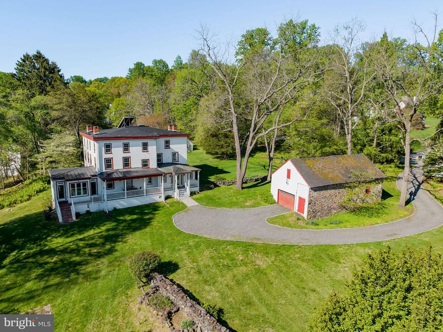 Welcome to 95 Indian Spring Road, a truly special 3 story, 6 bedroom, 3 full bath, 1 half bath historic property offering over 5,000 square feet of living space on 2.3 scenic acres in Media. Tucked at the end of a cul de sac in a beautiful neighborhood surrounded by other luxury homes, this property feels private and estate-like while still being close to everyday conveniences. Rich with character and thoughtfully updated over time, this home offers the rare combination of historic architecture, flexible living space, and unique outbuildings that create endless possibilities.
From the moment you arrive, the home’s welcoming front porch sets the tone, offering a charming place to take in the property’s peaceful setting. Inside, beautiful natural light fills the interior, built in shelving lines the living area, and original hardwood floors are found throughout most of the home, adding warmth, character, and timeless appeal. The main level offers generous living and dining spaces, multiple gathering areas, 3 working fireplaces, a thoughtfully updated kitchen addition, and convenient everyday functionality, including a first floor bathroom added as part of the kitchen expansion. The second floor features 3 bedrooms, 2 full baths, and a laundry room. The third floor offers 3 additional bedrooms, 1 full bath, and another bonus room with more storage. A full basement, partially finished with access to the outside, adds even more usable space for recreation, storage, or hobbies.
Outdoor living is another highlight of the property. In addition to the classic front porch, the rear brick patio and porch were completely redone in 2022 and feature beautiful white pillars that create a graceful transition from the home to the surrounding acreage. The 2.3 acre setting continues to impress with a two story garage barn offering excellent space for parking, storage, or workshop use.  An  historic Smokehouse sits on the property complete with a fireplace that creates a one of a kind opportunity for an art studio, fitness space, garden retreat, private office, or quiet escape. Whether enjoying morning coffee, entertaining, or quiet evenings overlooking the grounds, the outdoor spaces add to the private, estate-like feel of the property while still being close to the conveniences of Media.
The sellers have made meaningful updates during their ownership, including connection to township sewer in 2006, connection to AQUA public water in 2021, complete updated electrical services, installation of a high efficiency gas furnace in 2021, a newer water heater installed in 2022, and replacement windows on the first and second floors in 2023 and 2024, with the exception of the laundry room. Additional improvements include the front porch completed in 2002, the kitchen addition with partially finished basement, and ongoing care to the home’s systems and features.
This home holds rich historical significance. Known in historic records as the “White House,” the main residence was built in 1858 and showcases classic Georgian influence, stone and stucco construction, and the enduring presence of an early Pennsylvania estate. Historic records connect the property to the Bishop family and trace the land’s ownership history back to a William Penn grant in 1684, adding a remarkable sense of heritage to the home. This is  a rare opportunity to own a property with both architectural and local historical significance.
Ideally located just minutes from Media Borough, local parks, shopping, dining, and major routes, 95 Indian Spring Road is for the buyer who values history, space, character, and possibility. Schedule your private showing and experience all this remarkable property has to offer!