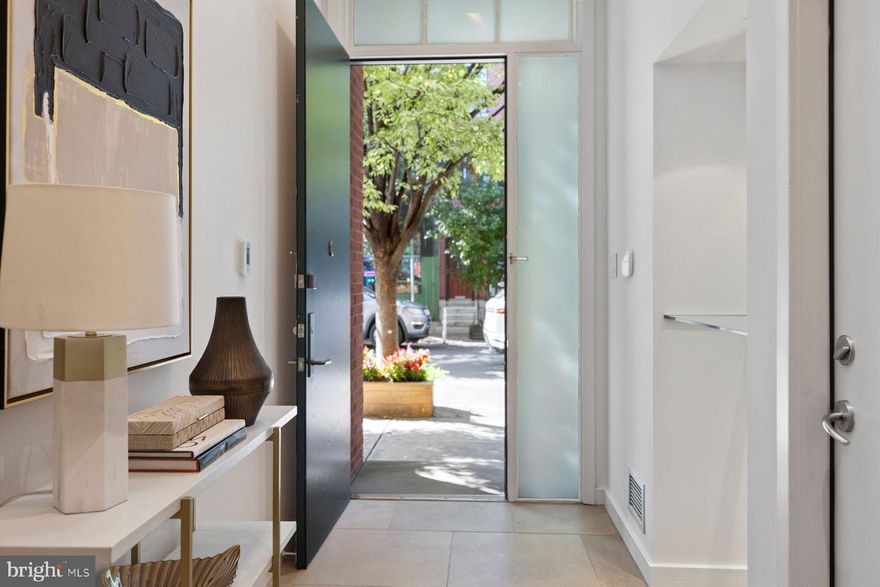 A perfect fit with the streetscapes of Rittenhouse Square, this brick townhouse rises three stories and offers a floor plan and contemporary finishes well suited to how many of us live today -- enjoy a main level with great flow to a private patio garden and note multiple offices for those who work from home. Enjoy the luxury of an attached one-car garage with interior access to a light-filled, expansive floor plan with elevator serving all levels. The grand-scale entry level offers a cook’s kitchen with a wealth of storage, big island and five-burner gas cooktop. The kitchen opens to the dining area as well as a casual seating area with fireplace and built-ins. Step outside to a private garden oasis with an exquisite waterfall. A formal living room on the second level is yet another beautifully designed, airy space with treetop views, built-ins and a second fireplace. On this level and separated by a landing with excellent storage is the primary bedroom suite. Overlooking the garden, this is a very restful, light-infused room with a wall of built-ins, multiple closets with organizers, French doors opening to a Juliette balcony and a deluxe bathroom. The bathroom is designed for two – two toilet rooms, two sinks, an oversized seamless glass shower and a Maax soaking tub finish this marble retreat. The third floor, with a landing topped with three skylights, presents two en suite bedrooms, an office and additional storage. As a bonus, the lower level is finished to include a home office lined in library shelving complete with rolling ladder. A wet bar with wine cooler and undercounter refrigerator completes this space. An adjacent full bath suggests this could also be an au pair suite/4th bedroom. In the Greenfield School catchment with access to both Rittenhouse and Fitler Squares, this townhouse is an outstanding choice for the buyer seeking a residence that balances design and quality throughout its 6,400 square feet of living space.