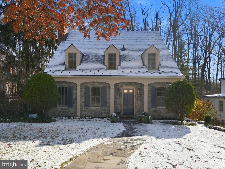 Immaculately updated, this classic Spring Valley stone Colonial cottage is ideally located on one of the neighborhood’s most desirable streets and backs directly to scenic Spring Valley Park.
This beautifully expanded home offers a refined approach to comfortable living. The upper level features four bedrooms and two bathrooms while the lower level has ample space for a potential 5th above grade bedroom.

Upon entering, the home opens to a thoughtfully designed interior that blends timeless character with modern comfort. A charming foyer leads through the center of the home to a front-room/side study and a light-filled living room showcasing classic proportions and elegant architectural details.  Anchored by a striking stone fireplace framed with crisp mill work this room benefits from excellent flow and warm hardwood floors, soft neutral walls, crown molding, and thoughtful details create a polished yet welcoming atmosphere.

Across from the living room, a formal dining room features a statement chandelier and built-in cabinetry with curated design and utility. Close by is an updated kitchen that seamlessly combines modern convenience with classic design, featuring granite counter tops, custom cabinetry, and warm hardwood floors. Expansive grid-pane windows and a large skylight fill the space with natural light, while the kitchen opens to the breakfast nook and family room overlooking Spring Valley Park. Direct access to an expansive rear deck helps create a seamless connection to the outdoors.
