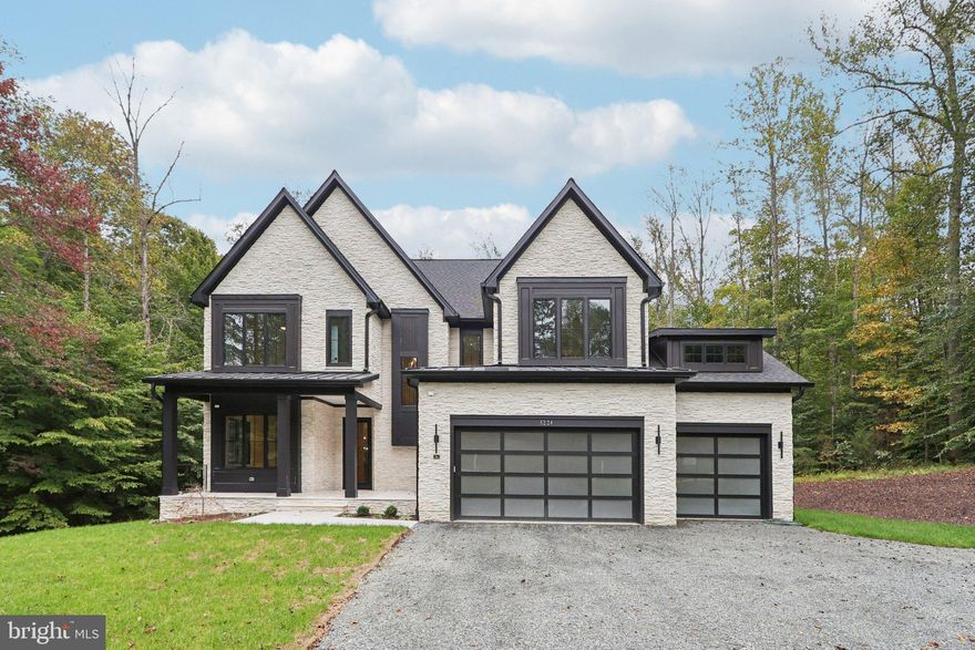 Introducing 5224 Trunnion Trail, an extraordinary new construction estate in the highly desirable Cannon Bluff community of Woodbridge. Built by Mike Garcia Construction, one of Northern Virginia’s top home builders since 1981, this residence sits on over 3.5 private acres and combines timeless craftsmanship with today’s most sought-after luxury amenities.

From the moment you arrive, the home’s elegant stone and siding exterior and designer garage doors set the tone for what lies within. Step inside to discover 10-foot ceilings on the main level and 9-foot ceilings upstairs, creating an open and airy feel throughout. The centerpiece family room boasts a dramatic floor-to-ceiling stone fireplace with heat management that allows a TV to be mounted above.

The chef’s JennAir kitchen is outfitted with premium appliances, leathered granite counters, and custom cabinetry, seamlessly connecting to the dining and family spaces. An elevator with touchscreen display provides convenient access to all levels, while a dedicated study, mudroom, and thoughtfully designed living areas make daily life effortless.

This home features two primary suites — one on the main level and one upstairs — each with spa-like bathrooms including curbless showers, freestanding tubs, and Kohler fixtures in matte black finishes. Additional bedrooms offer Jack & Jill and private en-suites, all with stylish tile and modern finishes.

Designed for entertaining, the expansive screened porch includes a built-in Coyote grill, outdoor refrigerator, and stainless-steel hood — ideal for gatherings year-round. Inside, details like faux wood beams, wide-plank laminate flooring, and custom closets elevate the home’s interior design.

Smart living comes standard with 400-amp electrical service, Cat6 prewiring, a full security system, and exterior camera wiring. Energy efficiency is ensured with spray foam insulation, dual HVAC zones, and high-performance windows and doors. The oversized garage includes two modern Clopay doors with frosted glass panels and WiFi-enabled openers.

Every detail has been carefully considered — from the 3-stop Savaria Eclipse elevator to the customized primary closets, pantry, and laundry rooms. With a tranquil setting, thoughtful design, and unmatched craftsmanship, 5224 Trunnion Trail offers a rare opportunity to own a one-of-a-kind estate in Northern Virginia.