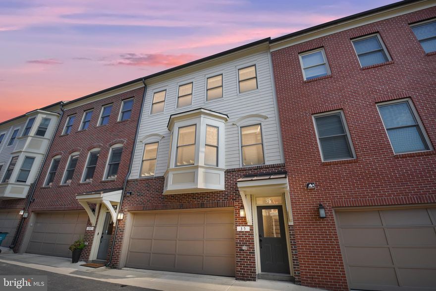 Imagine yourself living in a modern, highly upgraded townhome—situated in the middle of historic downtown Frederick! Walk to restaurants, shops, and downtown  events—with the convenience of being just steps from home! This chic, almost new Maxwell Square townhome affords you just that—great convenience and access to everything that downtown Frederick has to offer—including easy commuter access to highways and the Marc train and a walkability score that couldn’t be better! This lovely townhome shows like a model—with a light-filled lower level perfect for a family room, recreation area or office plus a convenient half bath and extra storage closet.  Walk out from the lower level to a grassy backyard! On the spacious main level, a wall of windows provides plenty of light in the open floor plan living area. Gleaming hardwood floors throughout the main level! Chefs will enjoy cooking in the  gourmet kitchen with granite, an extra large Center island/ breakfast bar, plenty of upgraded cabinetry and stainless steel appliances. Plus enjoy entertaining on the spacious deck that adjoins the kitchen. A well-thought-out floorplan includes a main level half bath and another large storage closet. The upper level Owner’s suite features a walk-in closet and luxury bath with dual sinks and extra large shower. Plus two more large bedrooms, a hall bath and convenient upper level laundry. All this, and an attached two car garage plus additional guest parking. With great proximity to so many of Frederick’s amenities, this lovely home won’t last long!